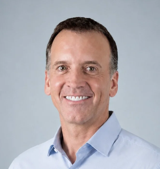 A portrait of a middle-aged man, who is a member of the Clube Pickleball Lisboa Board, with short dark hair, smiling, wearing a light blue collared shirt, against a plain light gray background.