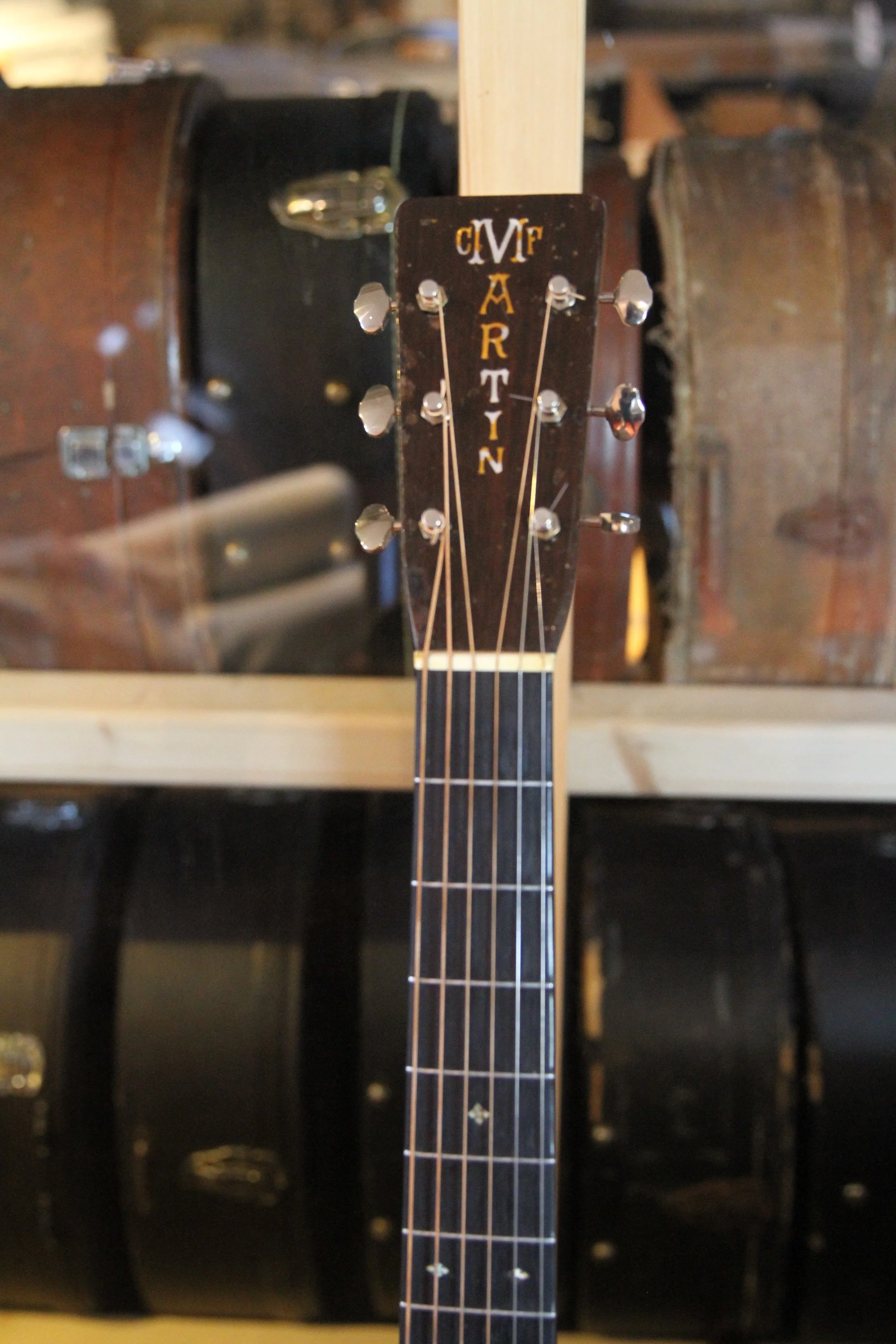 headstock, nut upper fretboard of a Martin archtop guitar, with tuning pegs.
