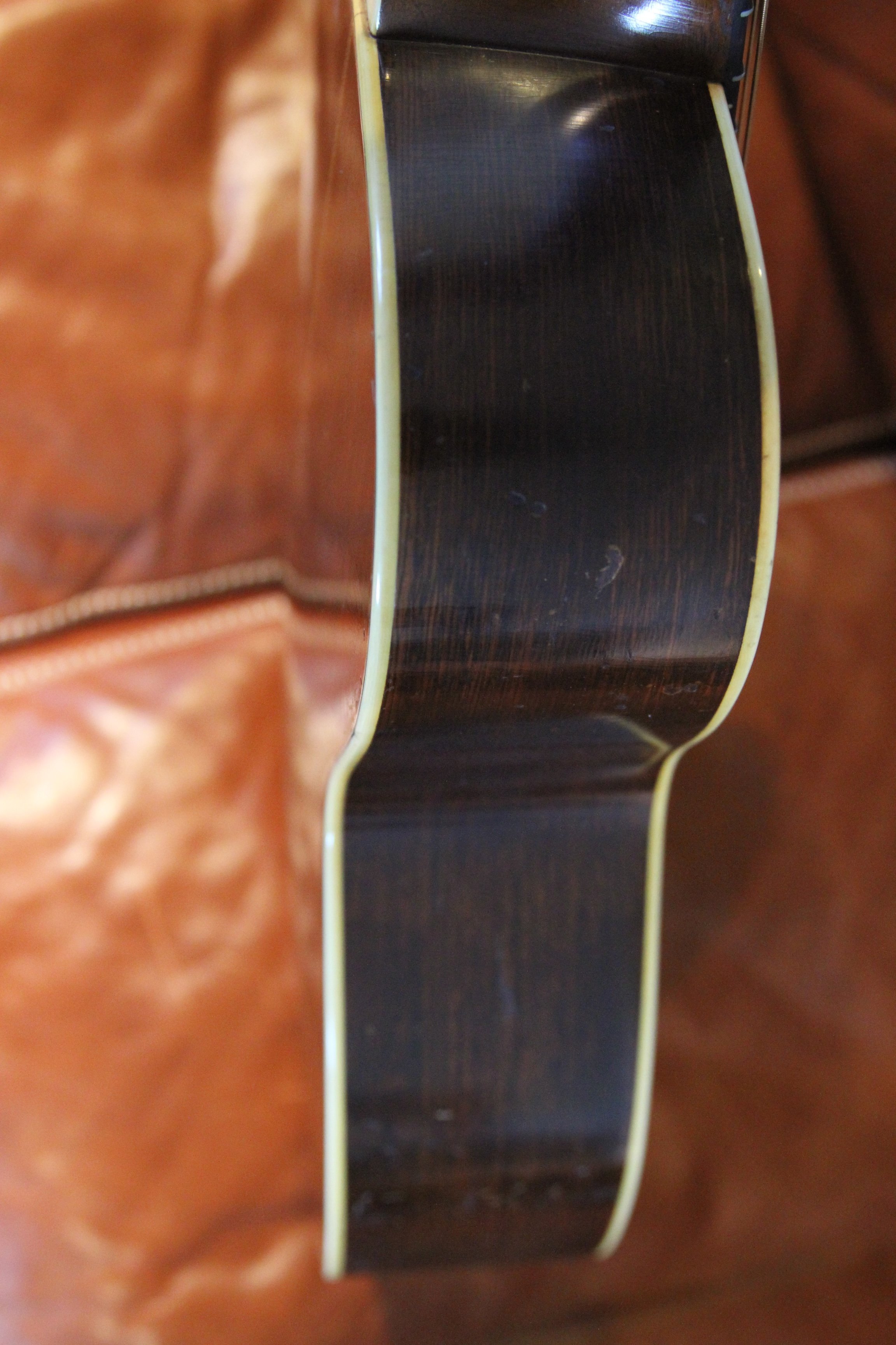 Close-up view of bass-side of double bound vintage guitar
