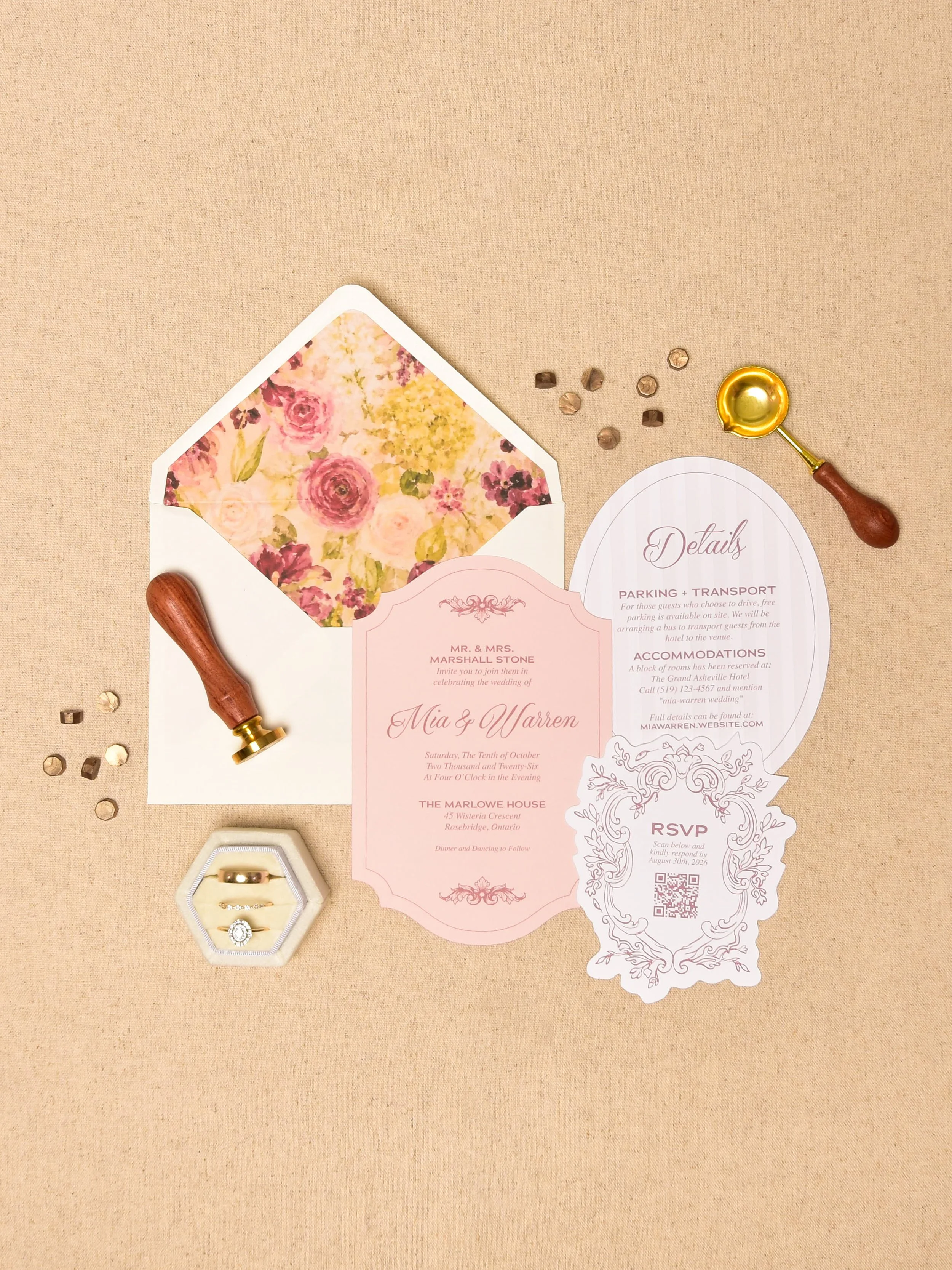Wedding invitation, rings in a hexagon ring box, a gold wax seal stamp, and small decorative confetti on a beige background.