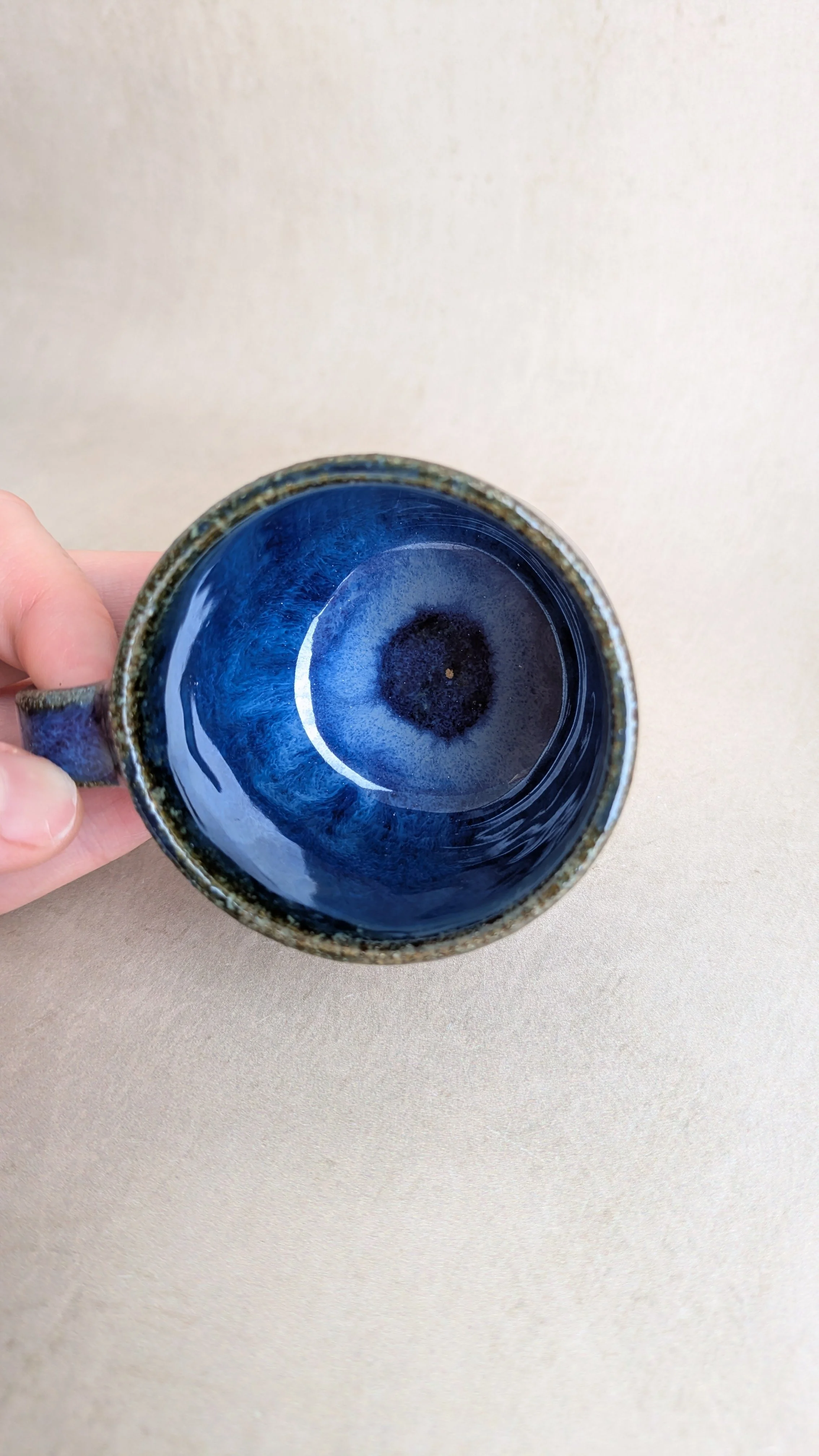 Top view of Azul Lazuli mug showing deep blue interior glaze with darker centre and greenish brown rim.