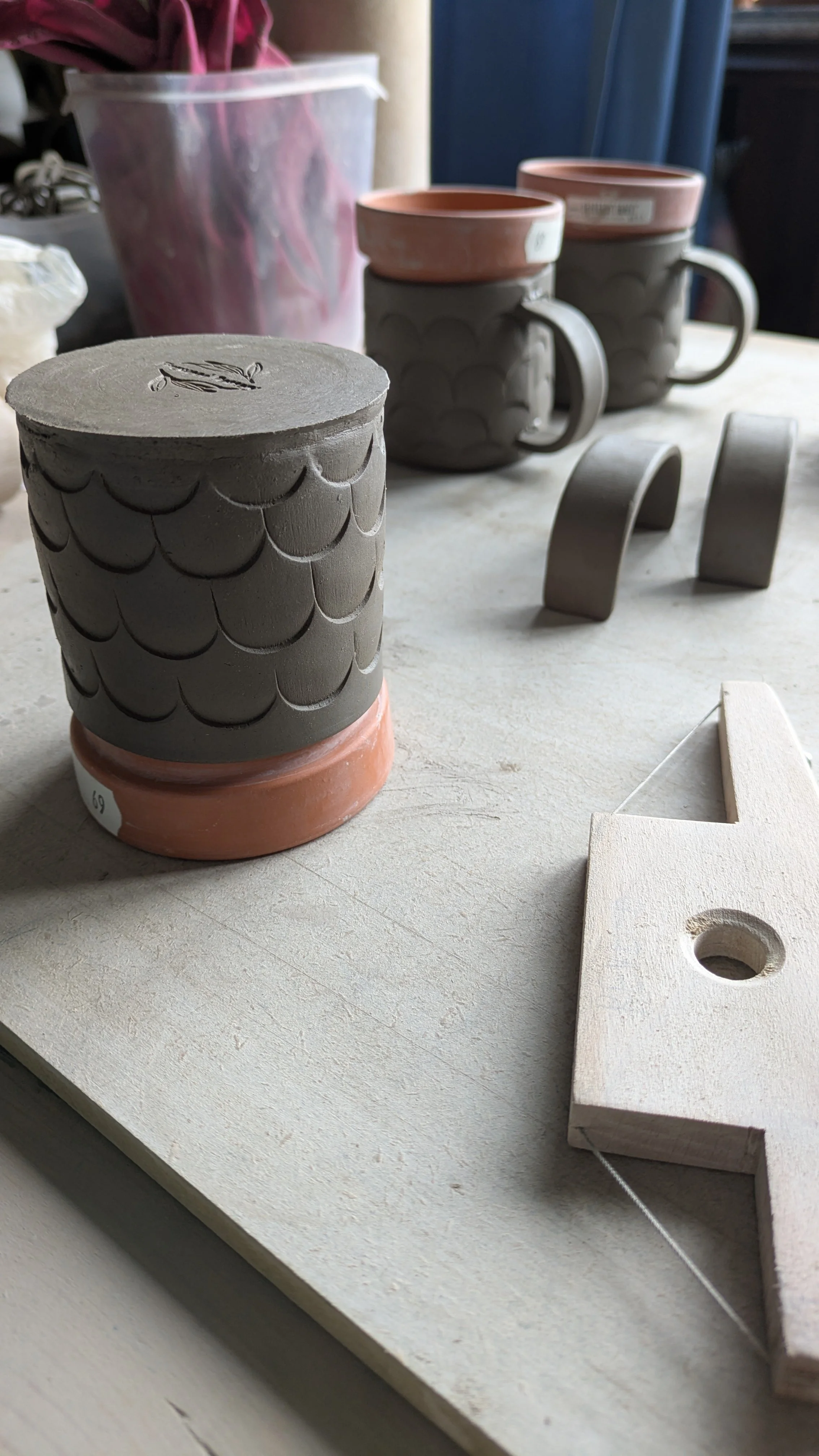 Some little pottery mugs in progress with handles ready to attach and tools