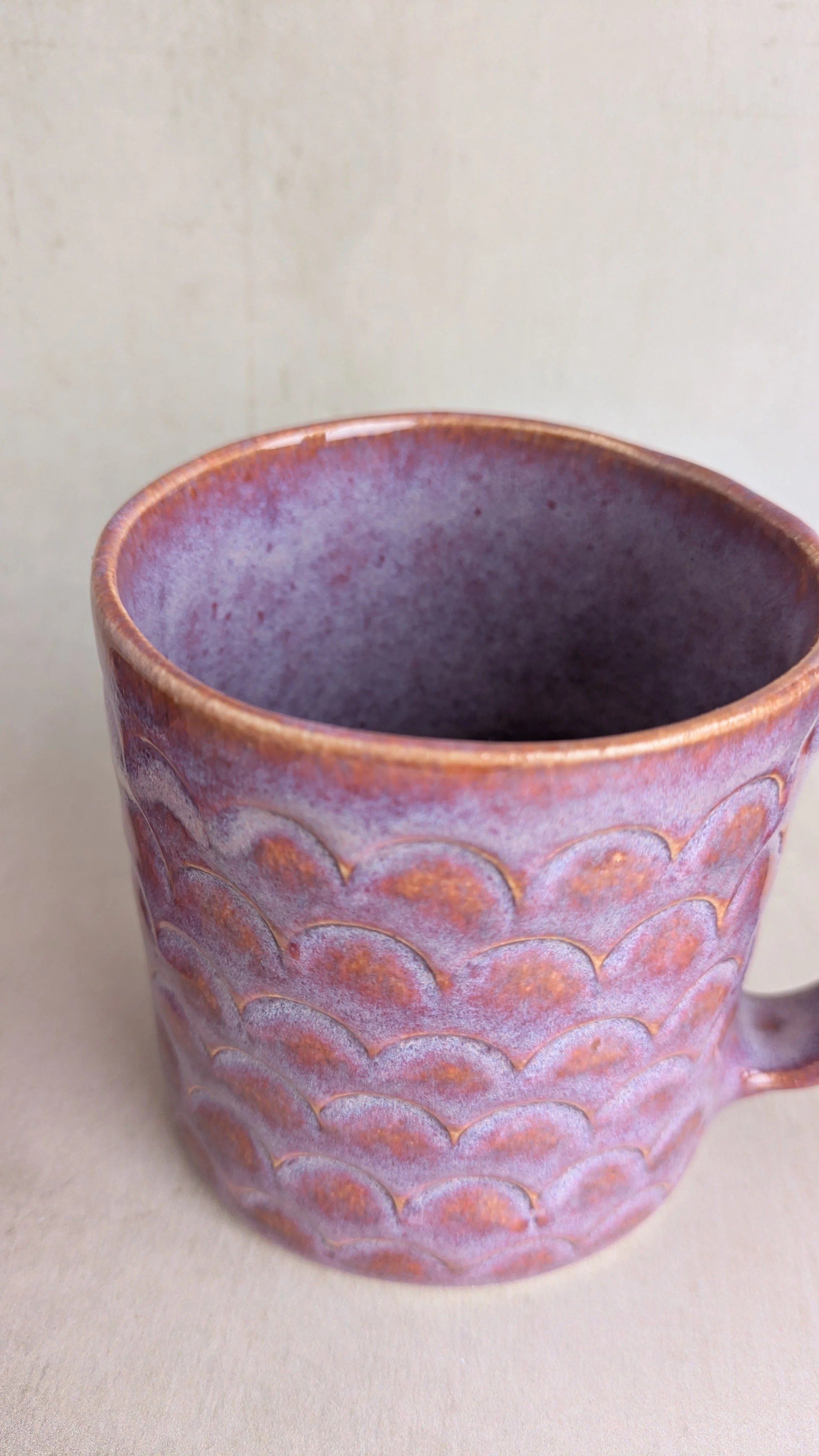 Close-up of the purple arch mug showing scalloped texture and glaze details.