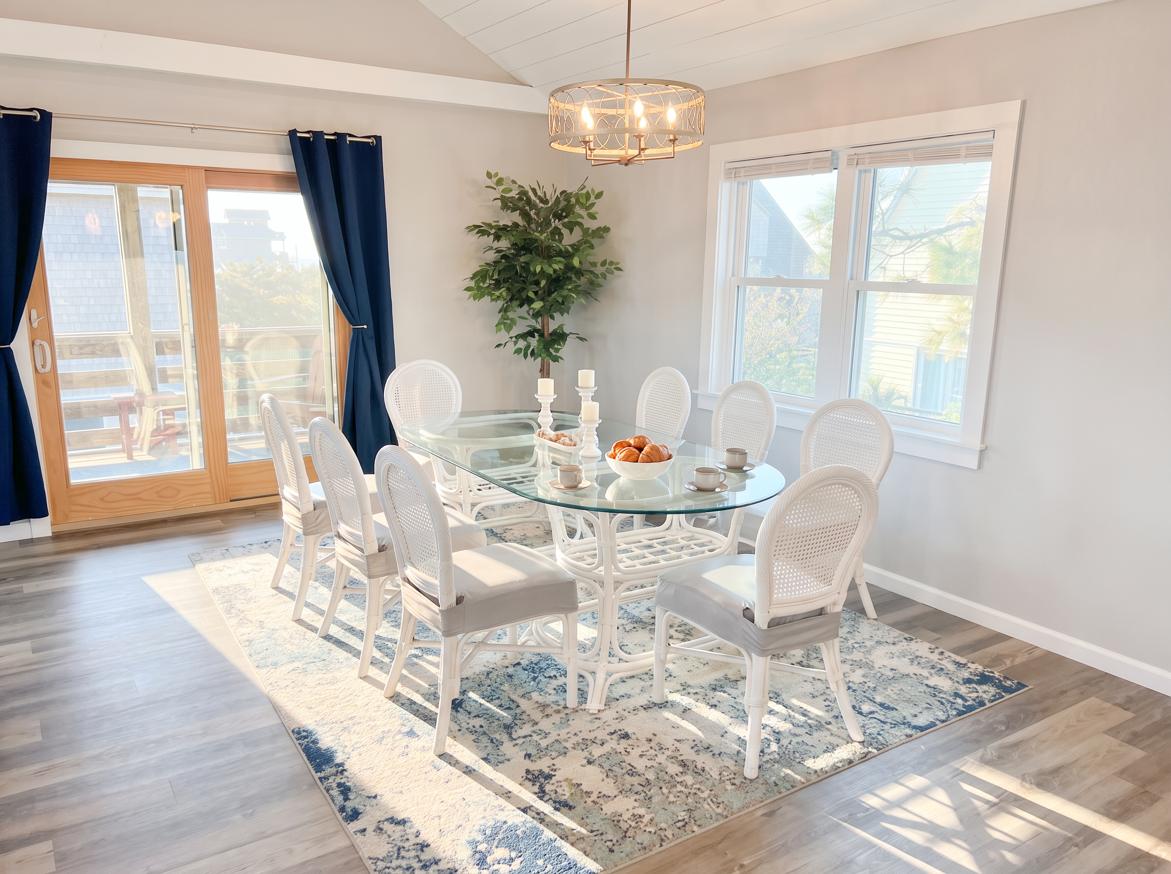 Dining area with sliders leading to an outdoor screened porch with sun shades and seating for 4!