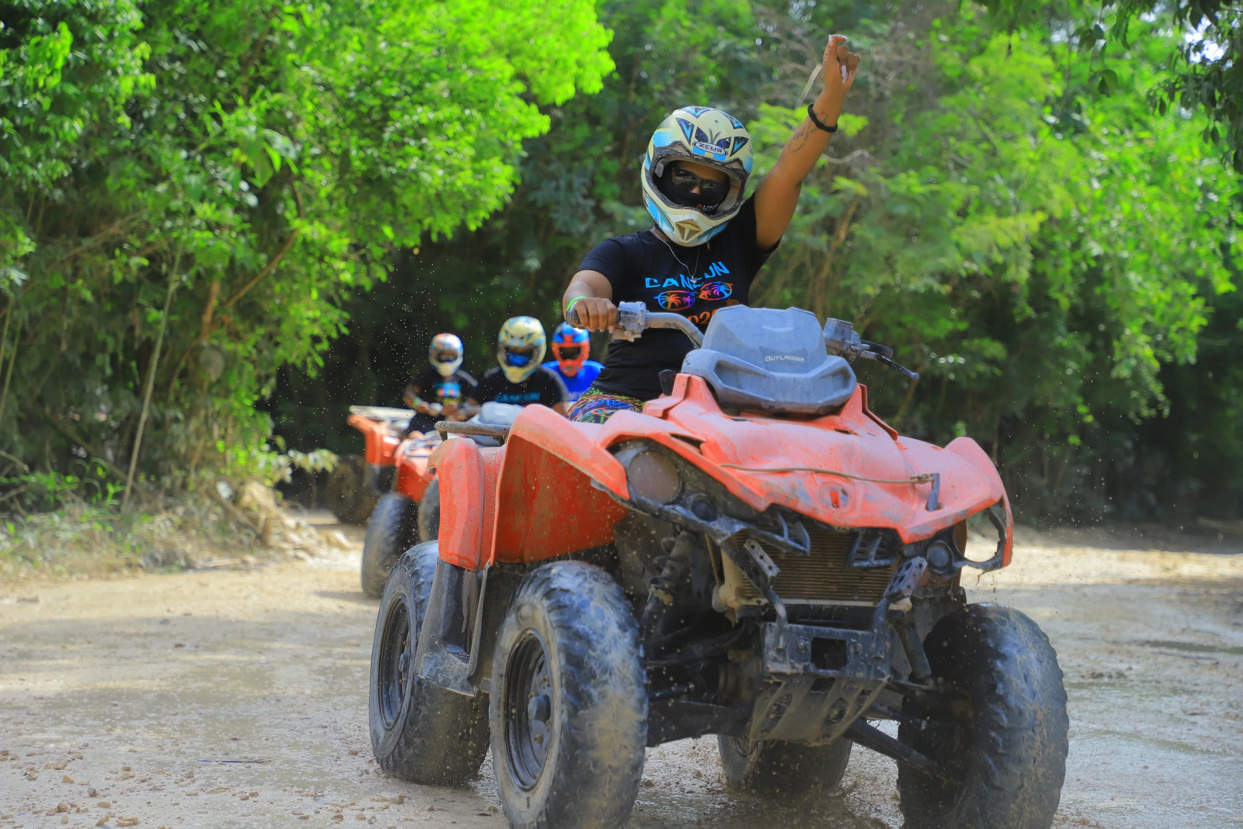 Travelers enjoying an ATV adventure through a tropical landscape during vacation.