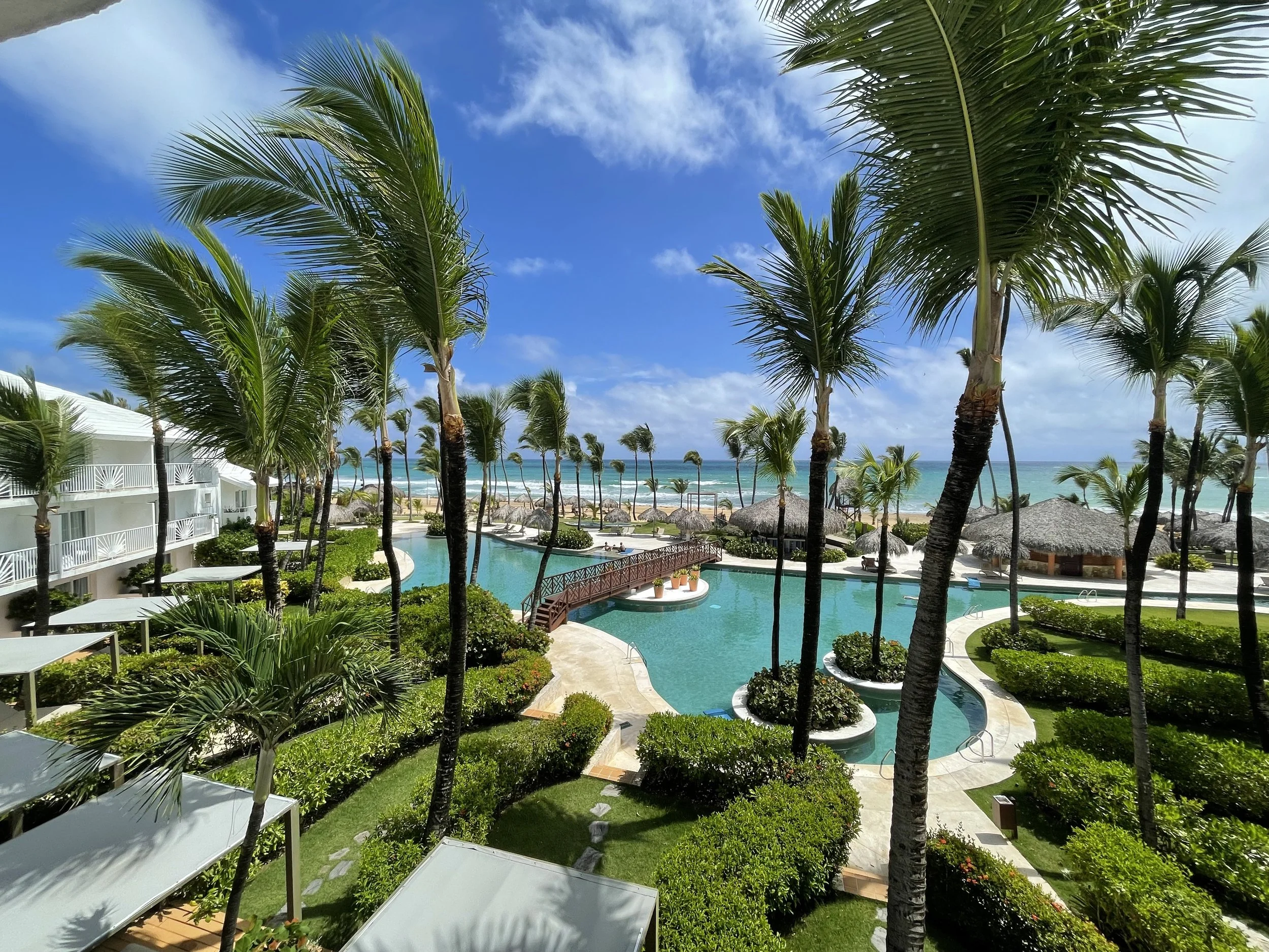 Luxury tropical resort featuring palm trees, pools, and beautiful ocean views.