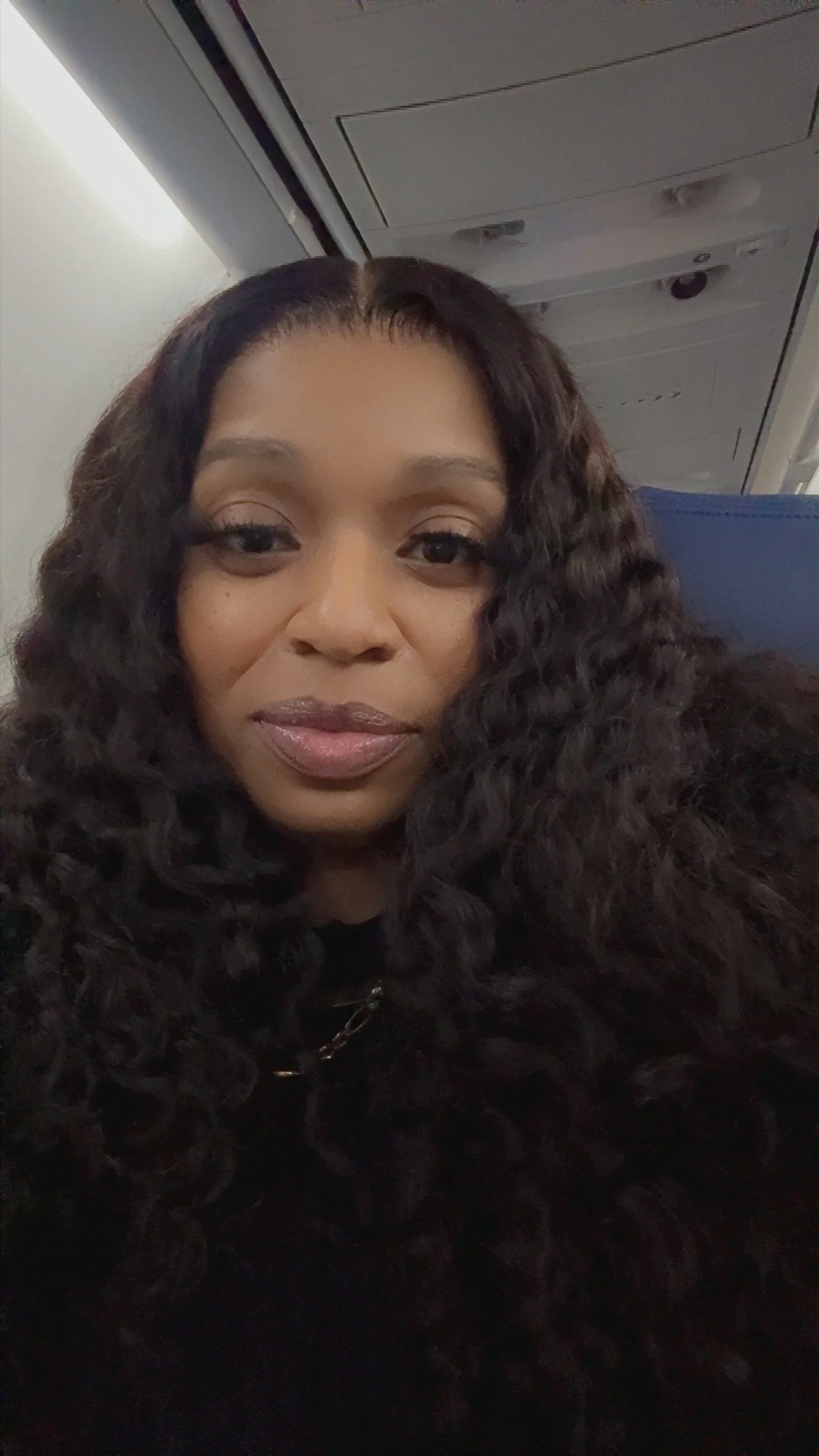 Erica aboard a flight, excited to begin her next travel adventure.