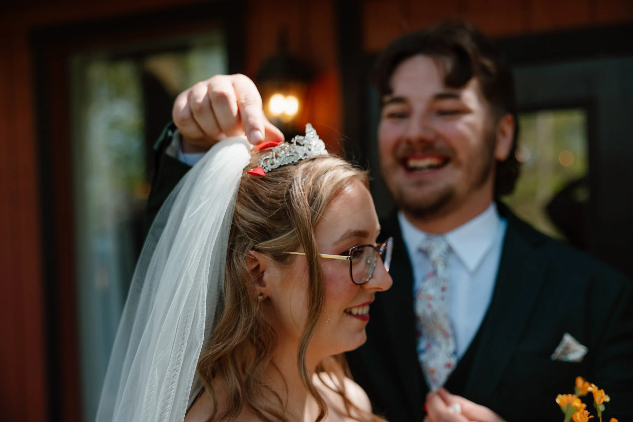 candid-groom-adjusting-bride-tiara-mohican-castle.jpg