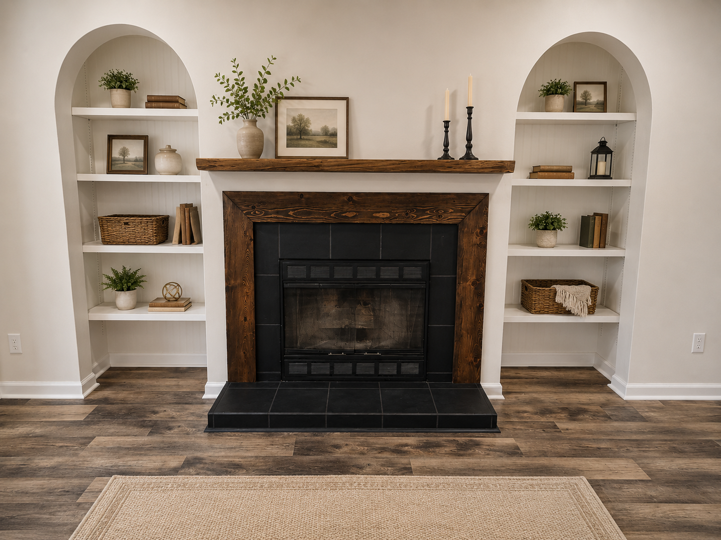 Living room fireplace with wooden mantel and built-in white shelves on each side, decorated with plants, books, and decorative items; hardwood floors and a beige rug. Completed by Sawdust.