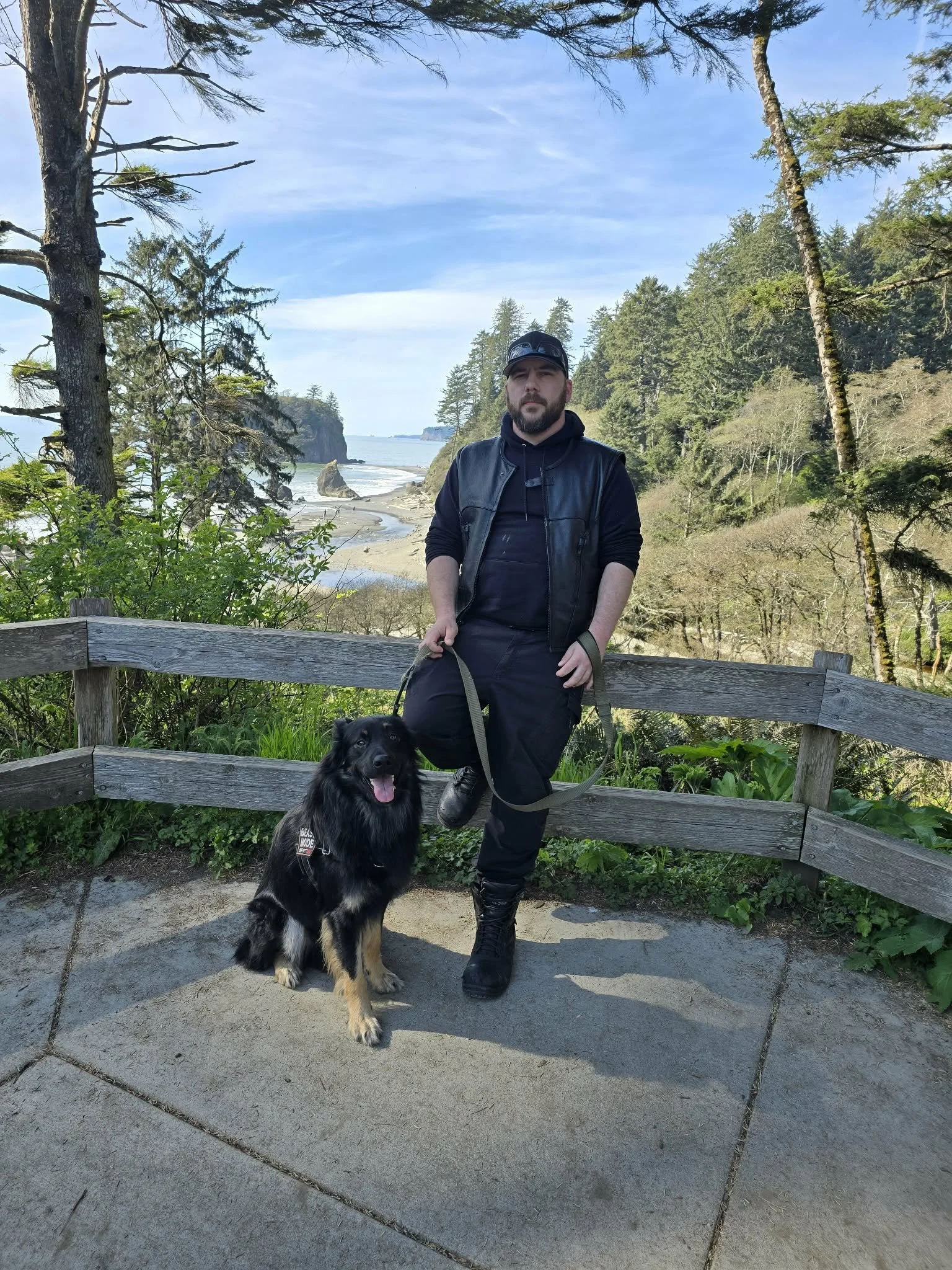 Ben Hulet, founder of Citadel Kinetic Intelligence, standing with his dog on a coastal overlook in the Pacific Northwest