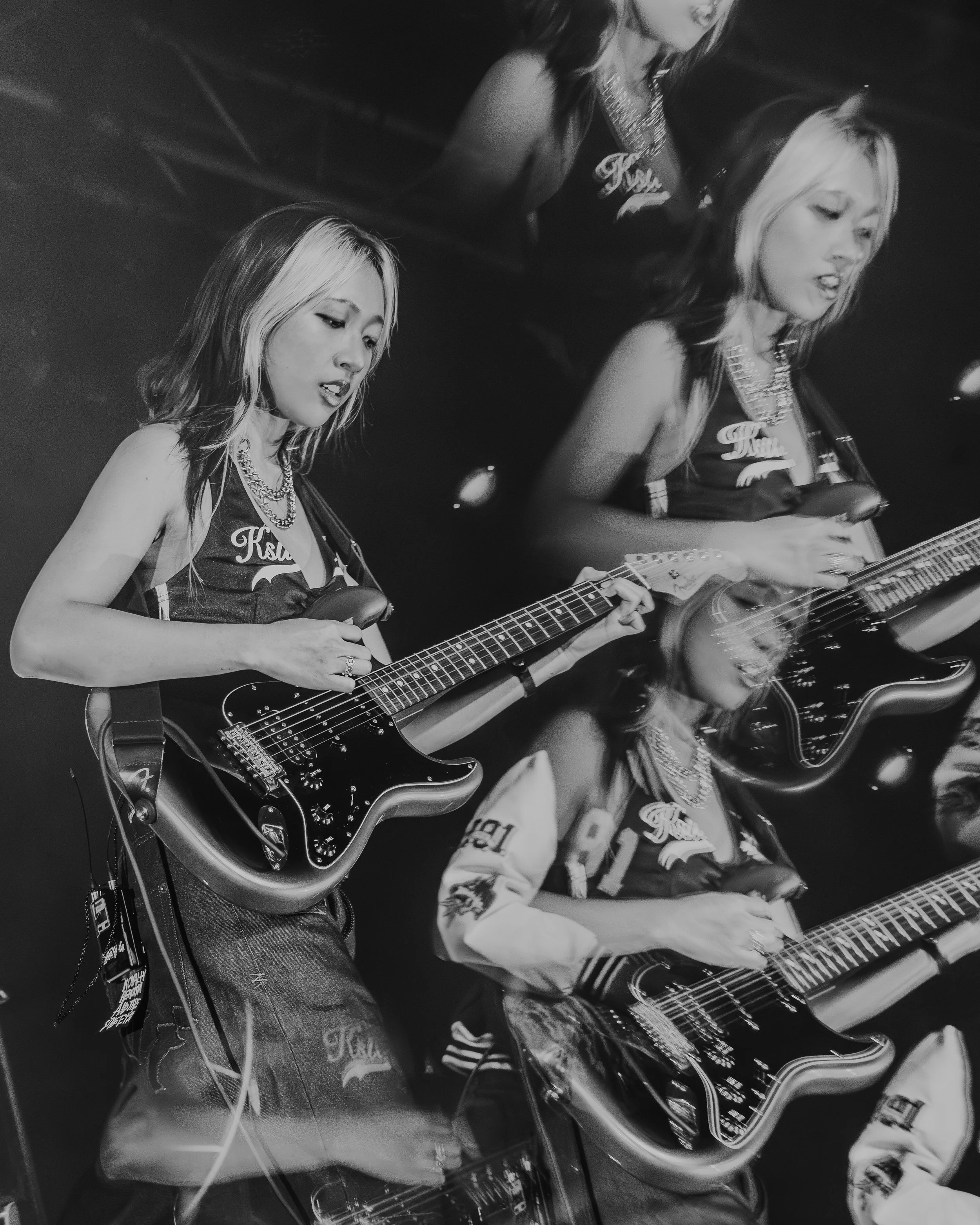 Black and white photograph of Hannah Bahng singing and playing a guitar at Electric Ballroom in Camden in 2026 distorted used a glass prism for artistic effect