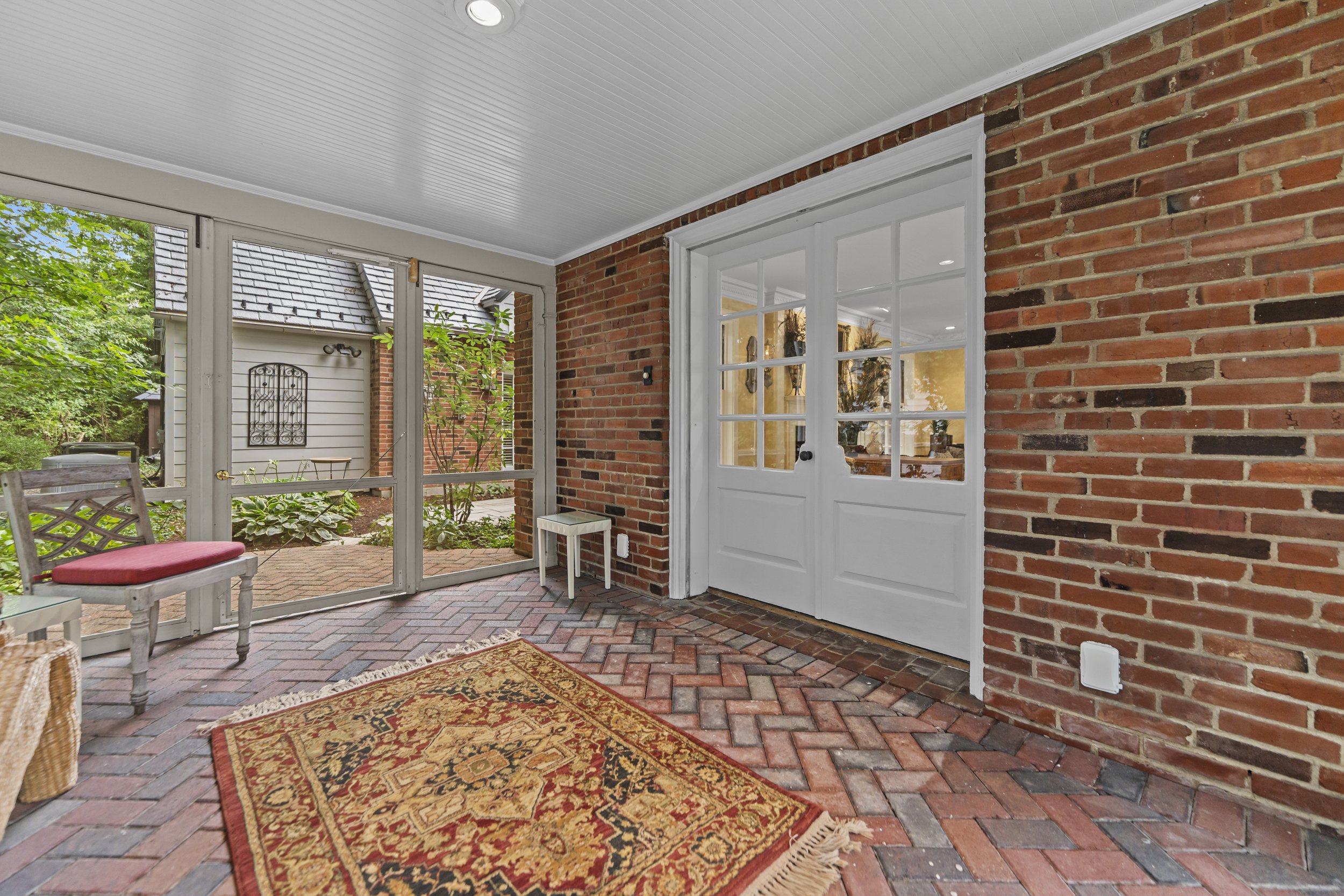 Covered brick patio with direct access to the home and adjoining screened porch.