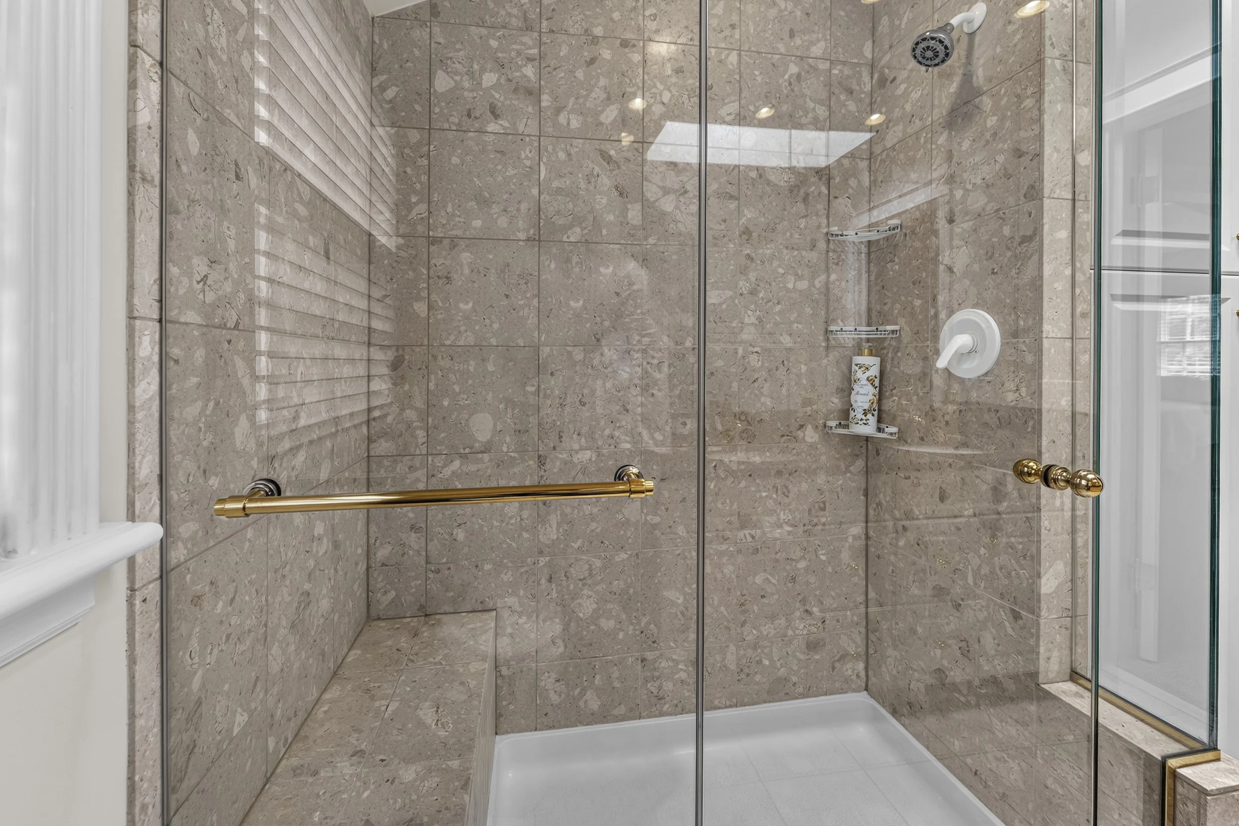 Spacious walk-in shower featuring premium tilework and modern fixtures.