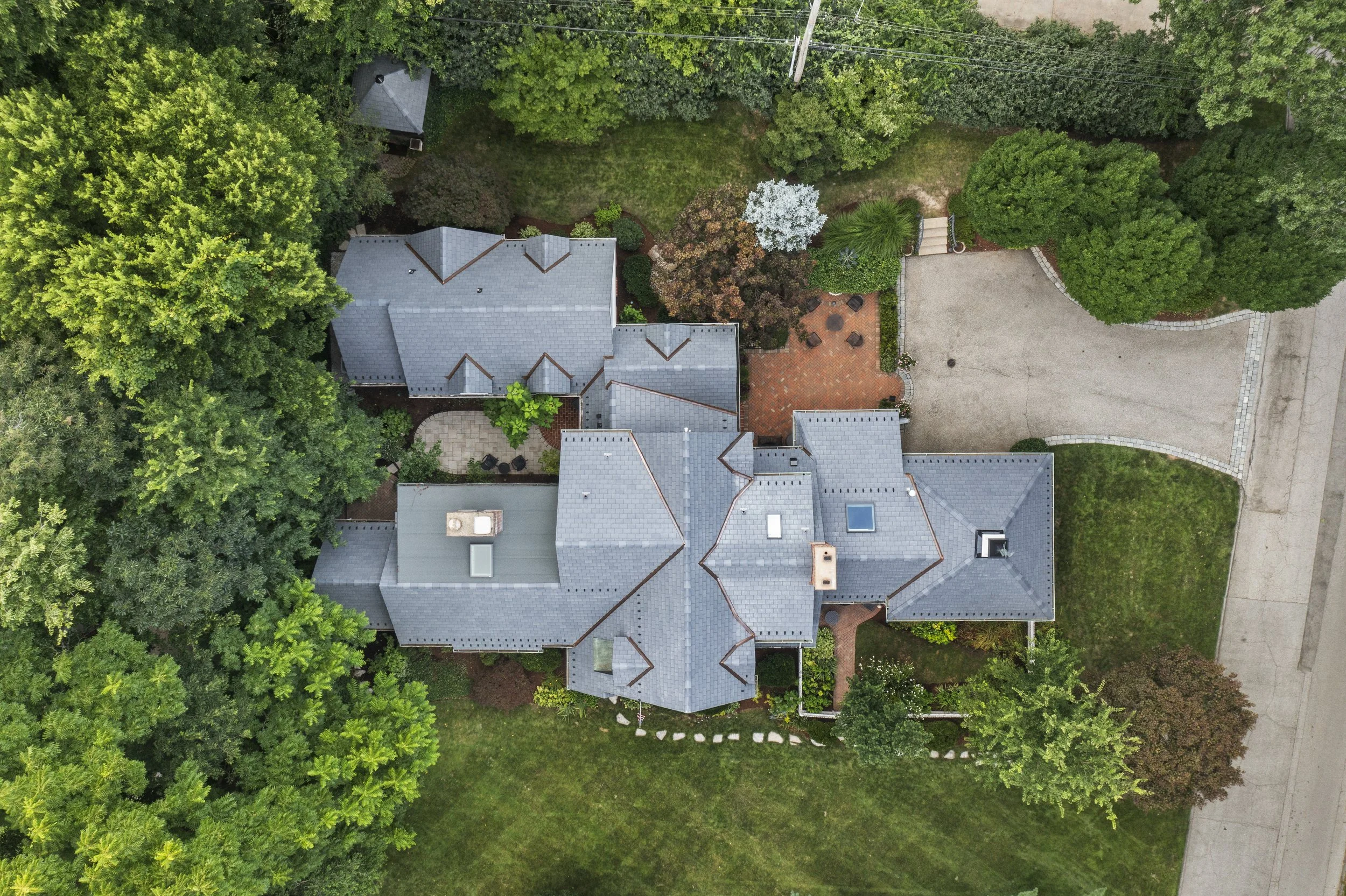 Aerial view of 17 Devon Road highlighting the home's private setting, mature trees, landscaped grounds, and outdoor living spaces.