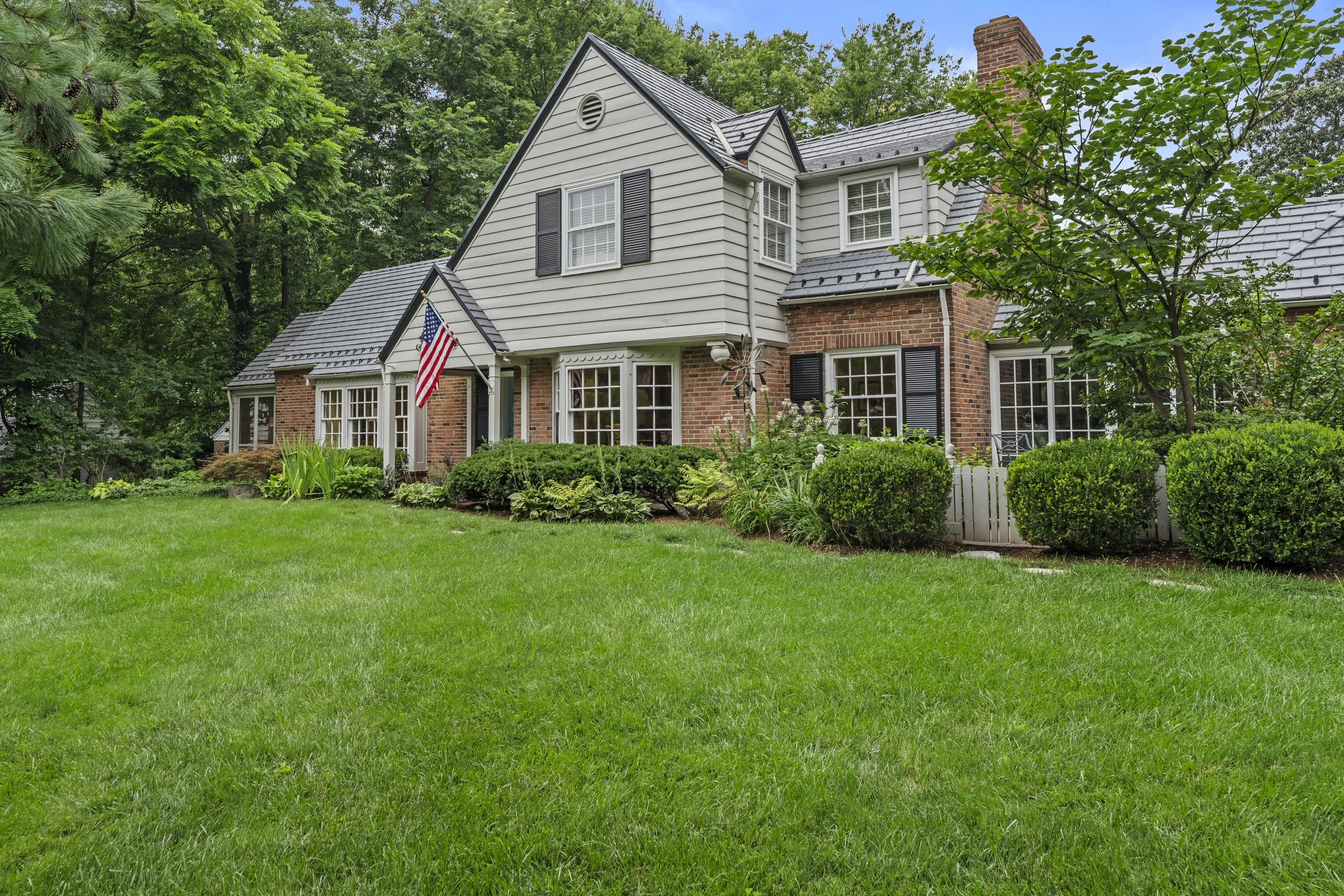 Exterior view highlighting the home's traditional architecture and beautifully maintained grounds.