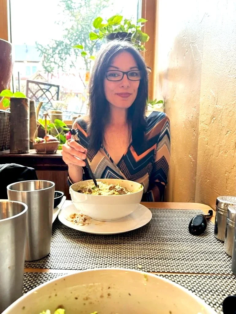 Kylie Ransom enjoying a nourishing meal at a local restaurant, reflecting her balanced, evidence-based approach to healthy eating.
