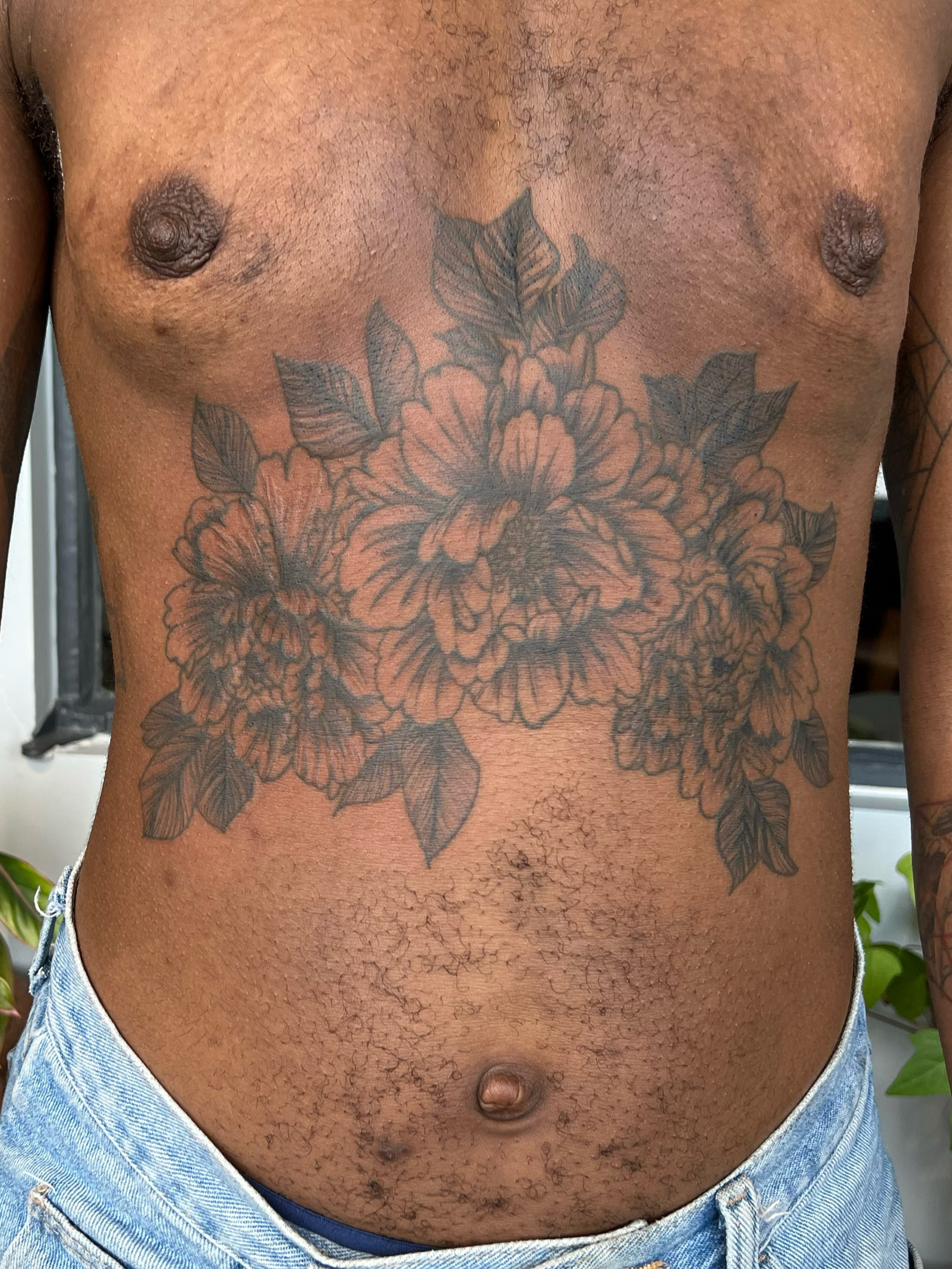 reworked sternum tattoo of peony florals 