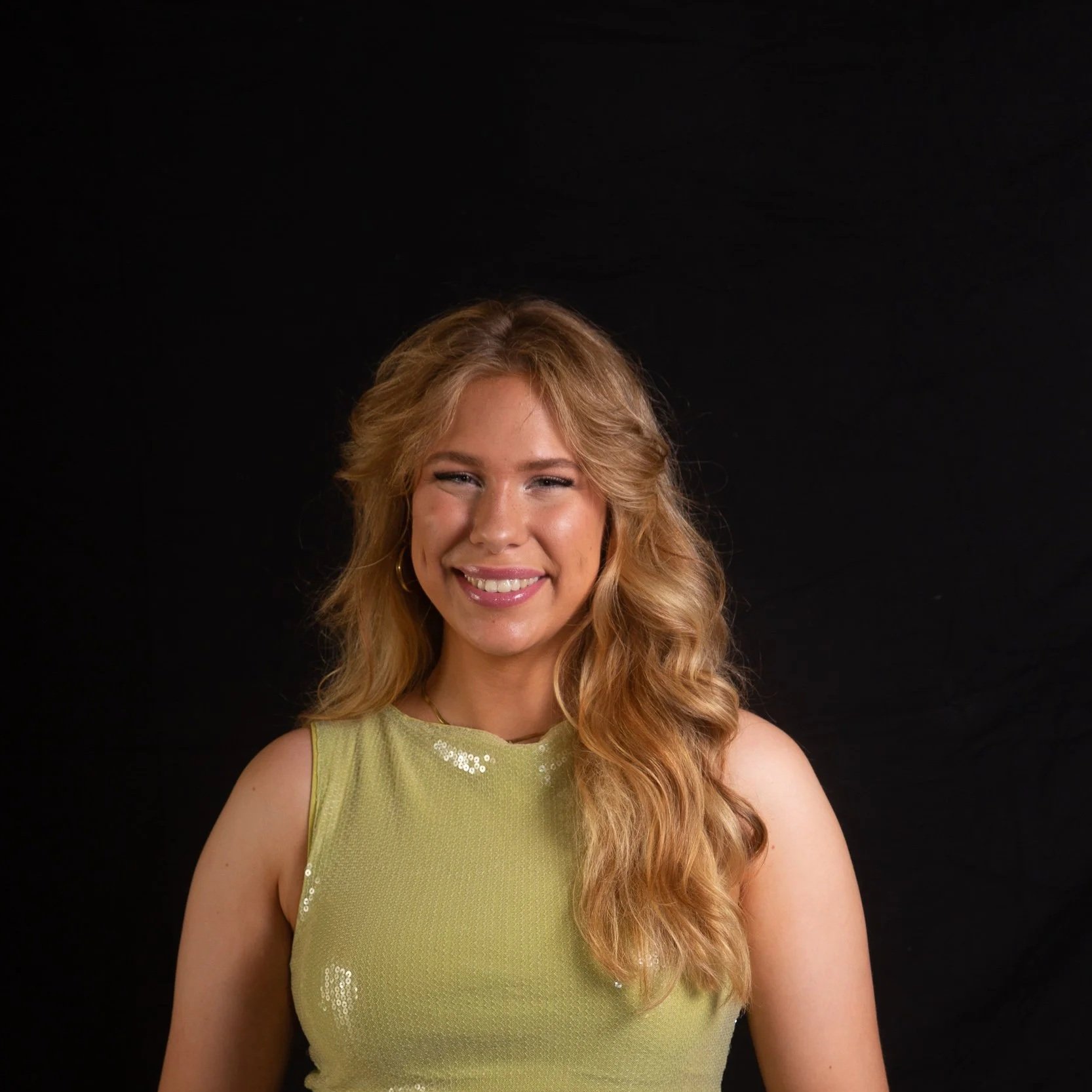 Headshot of smiling female tutor with long braids wearing a lanyard.