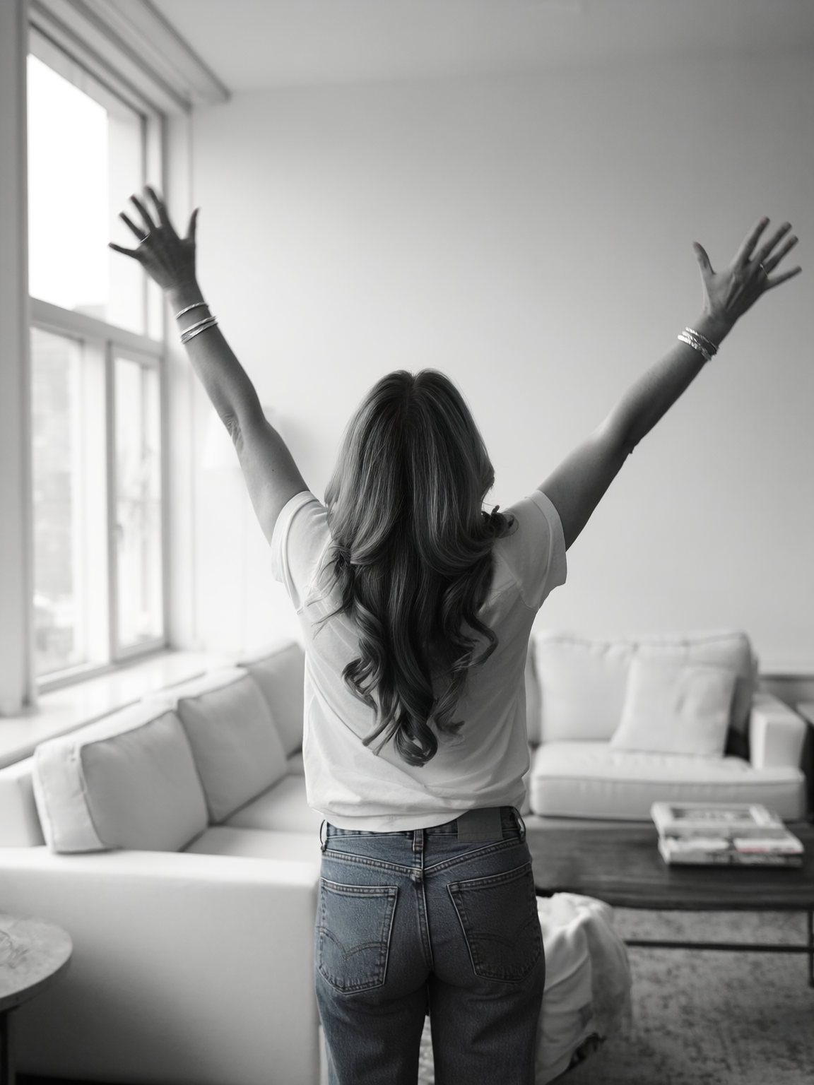 Woman with arms raised feeling energized at home — wellness membership at NORRENNE, League City, TX