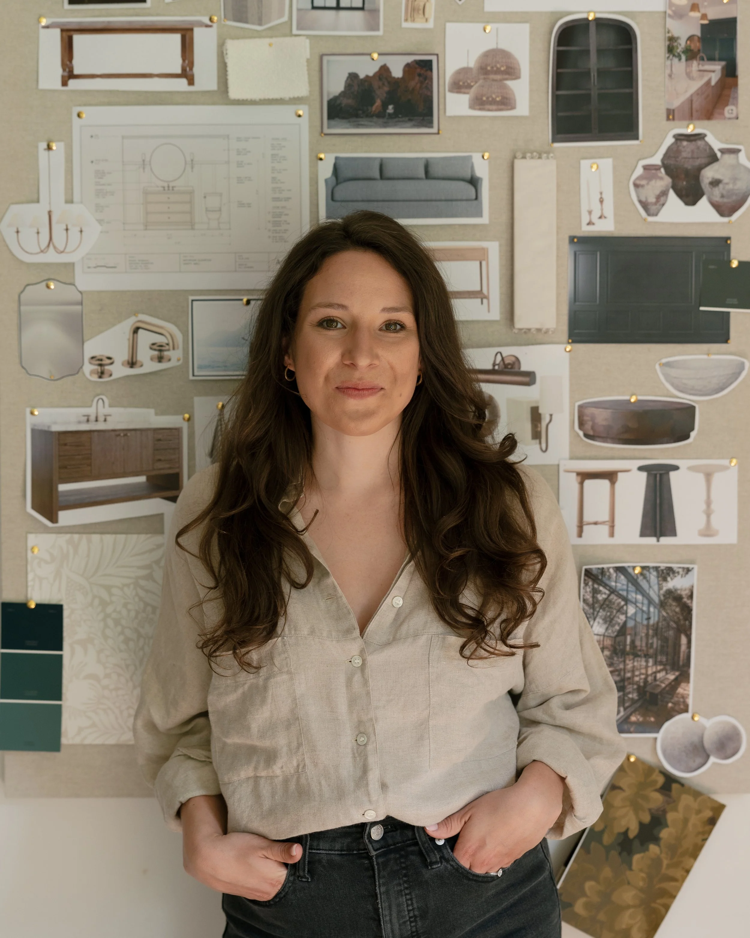 Interior Designer Sarah Sherer in front of a collage of interior design images pinned on a wall for design inspiration in here Columbus Ohio Studio.