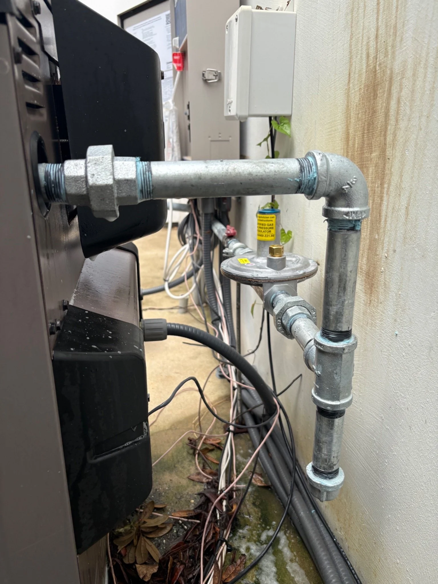 Exterior natural gas line and pressure regulator installed by Shoreline Plumbing Solutions in Pensacola, Florida