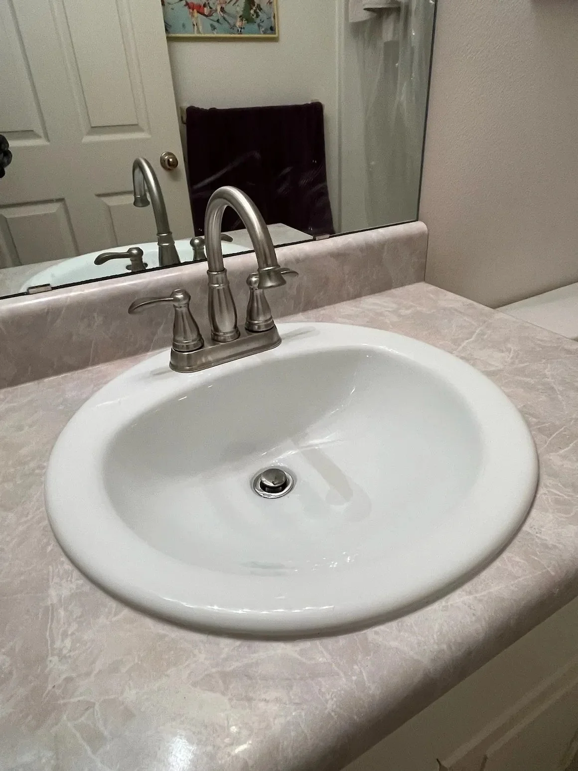 Bathroom sink and brushed nickel faucet installed by a Pensacola plumbing contractor