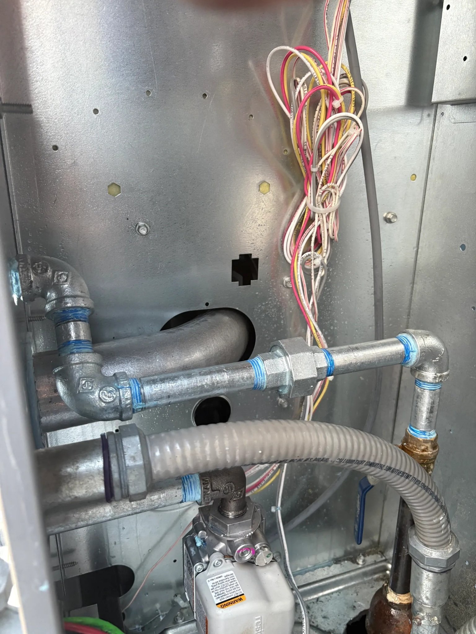 Black iron gas piping and connections installed inside an HVAC system in Pensacola, Florida