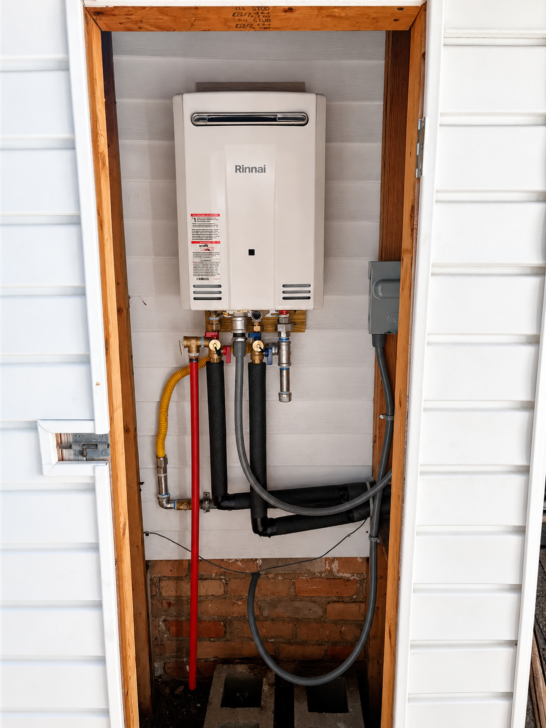Wall-mounted tankless water heater installed in Pensacola with venting and plumbing connections.