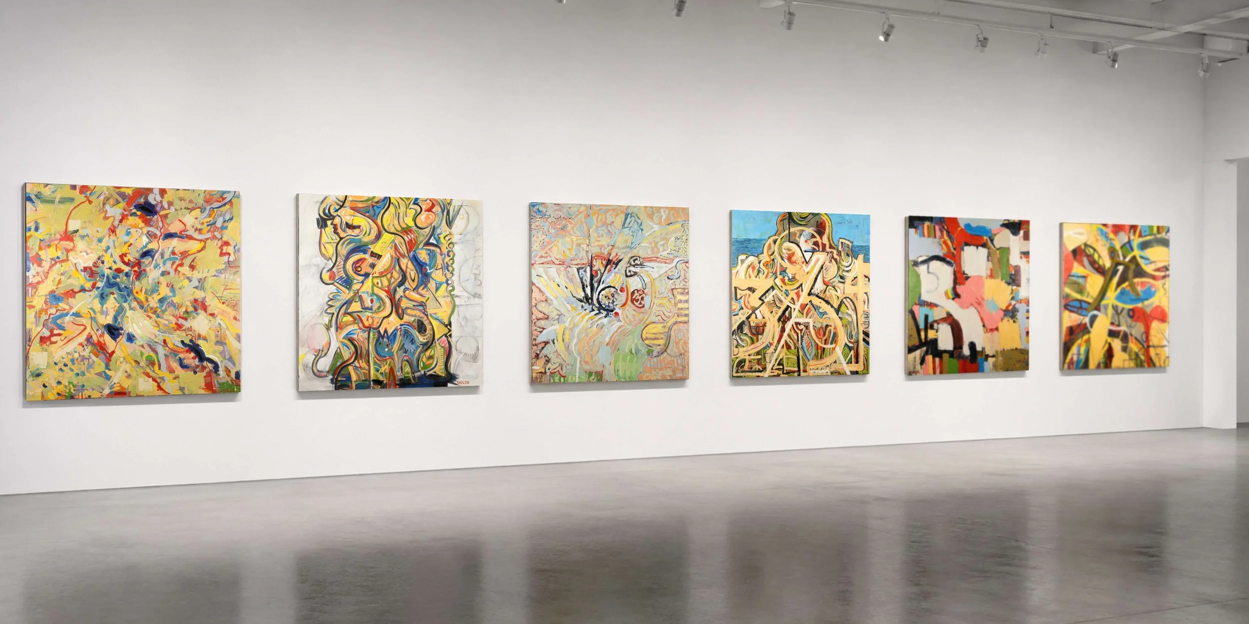 Six colorful abstract paintings displayed on a white gallery wall.
