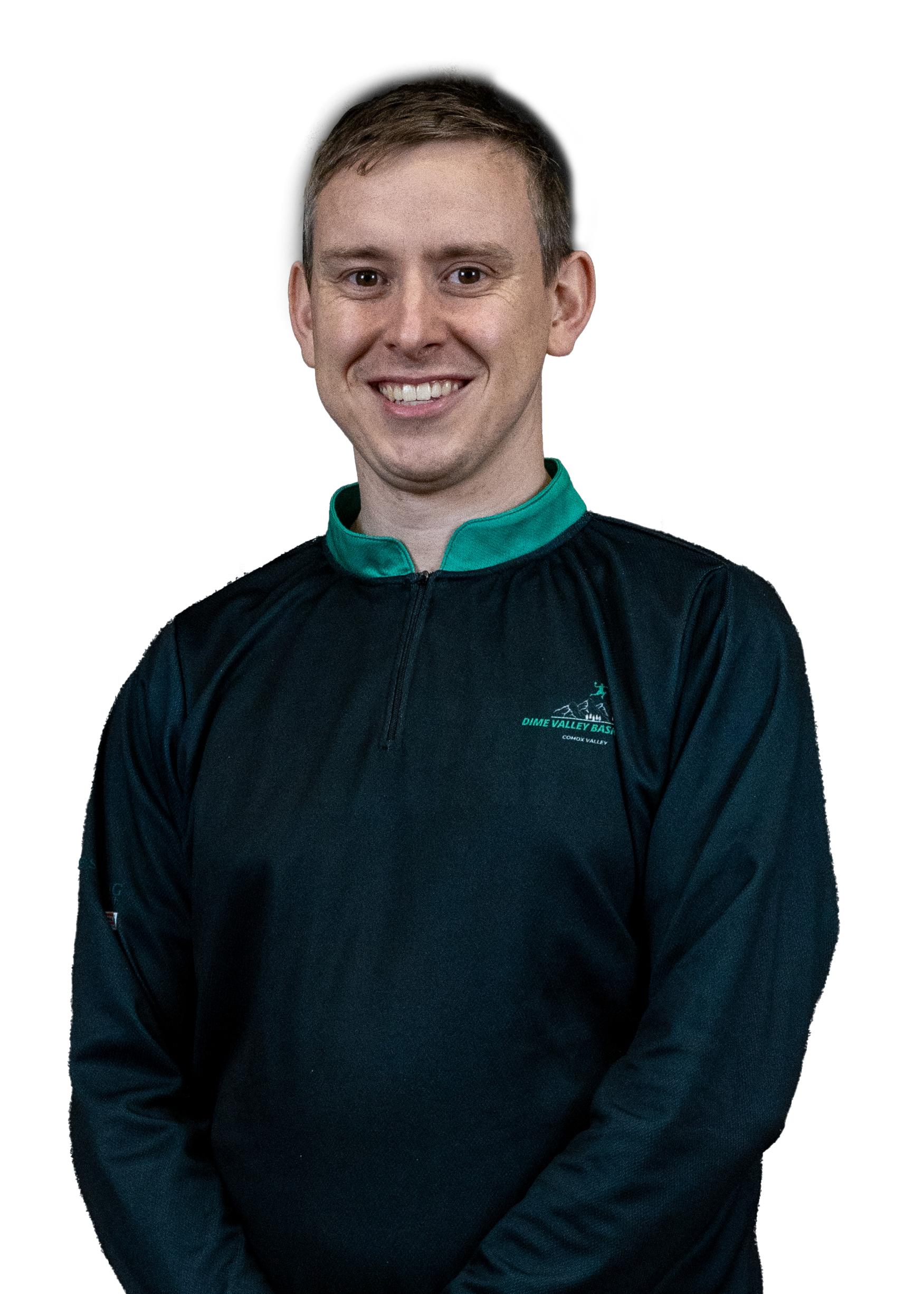 Man wearing a black jacket with green trim, smiling, against a plain dark background.