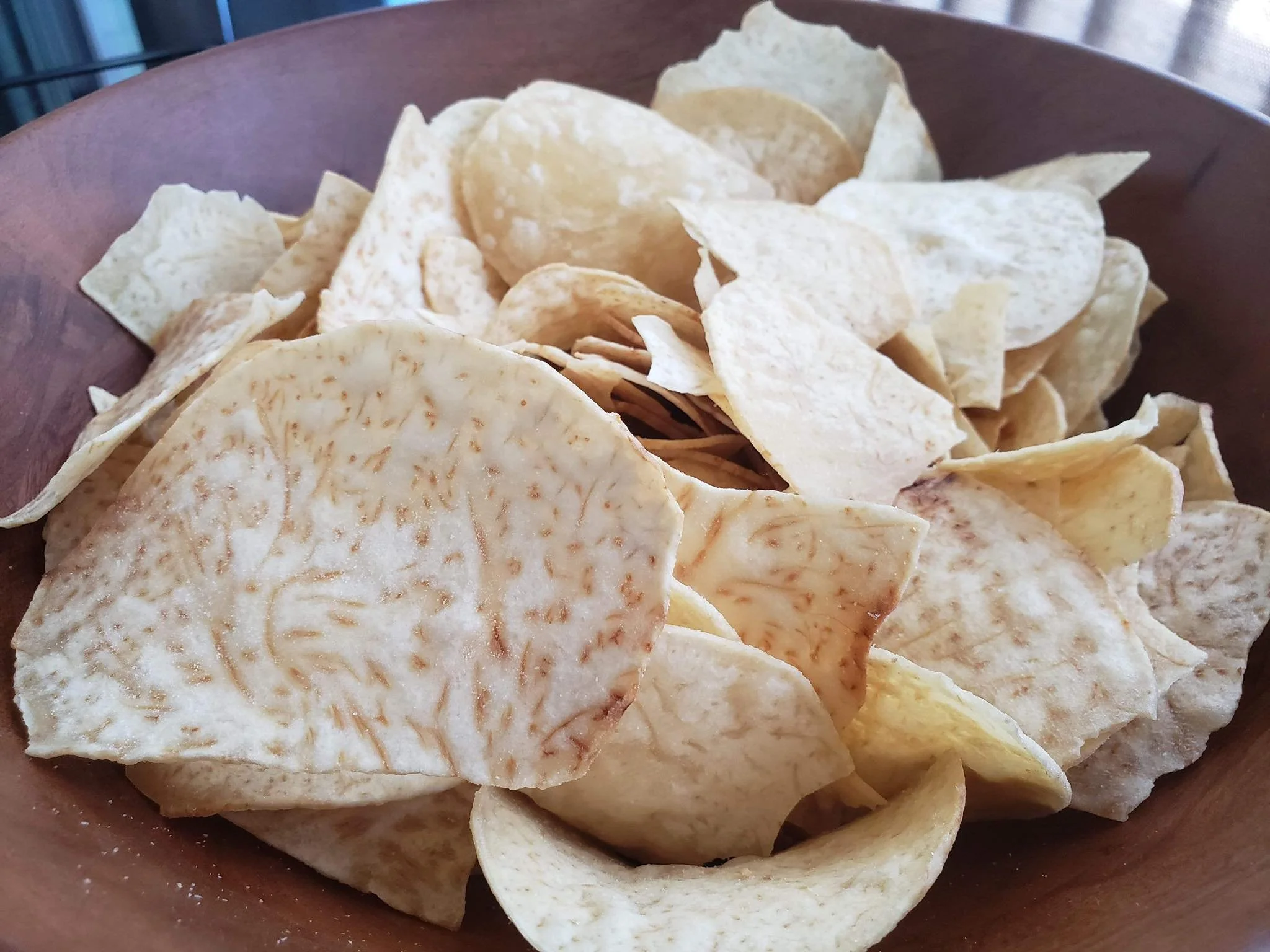 A wooden bowl filled with moana taro chips.