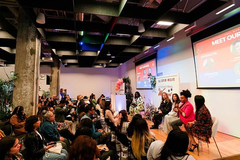 Panel discussion at a conference with an audience in a modern event space.
