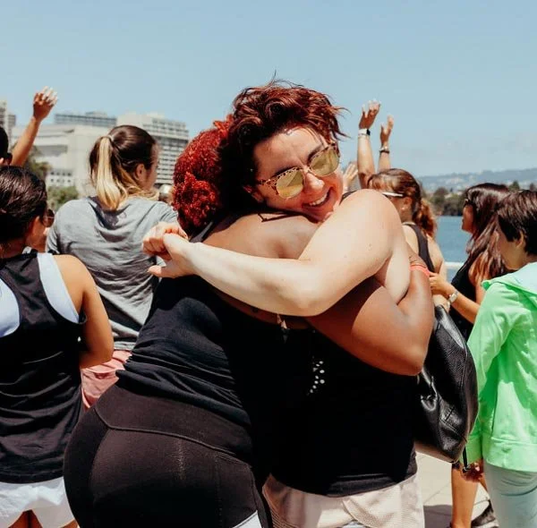 Sol Sisters members hugging at an event outdoors