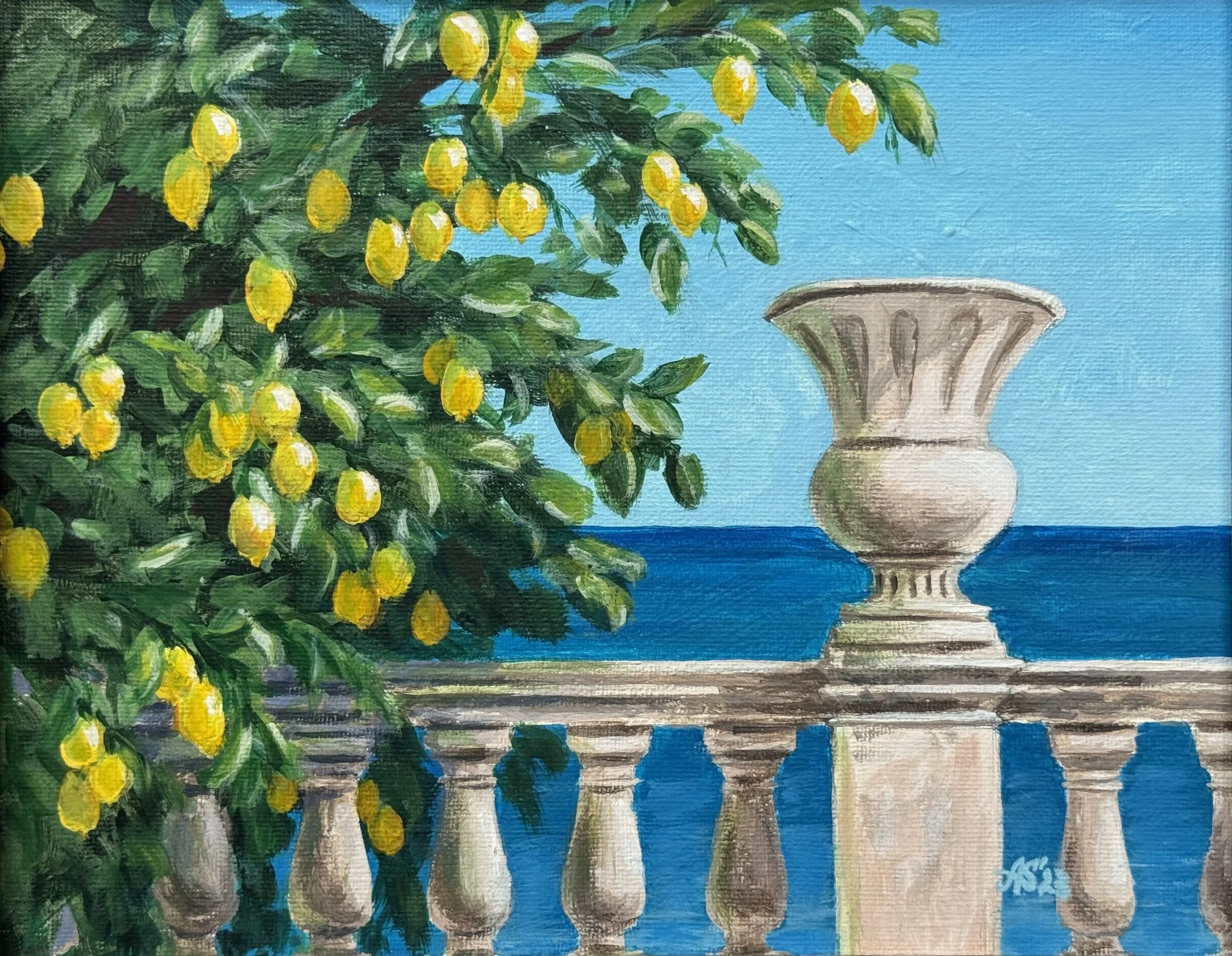 A view of a lemon tree with yellow lemons and green leaves on a balcony a white urn with a sea in the background in Italy.