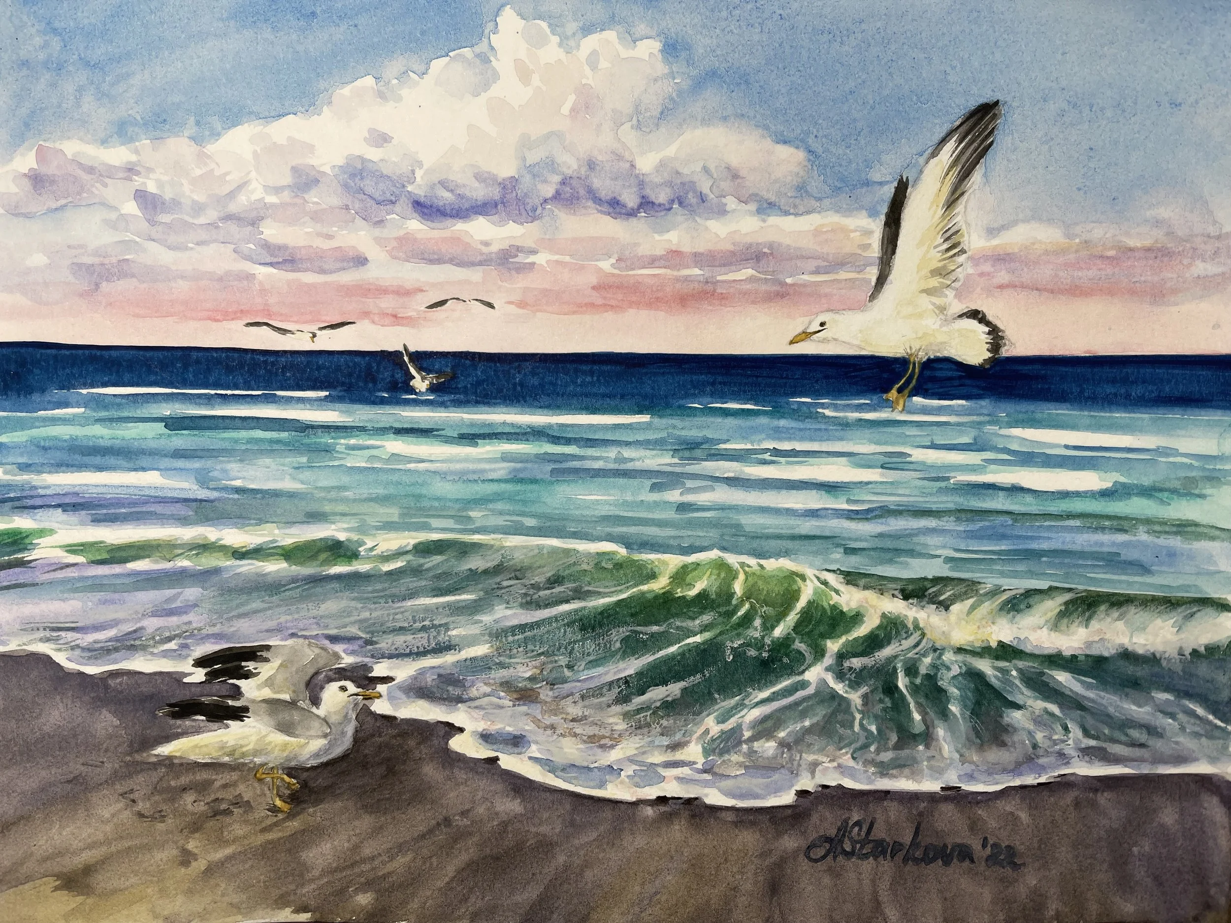 A watercolor painting of a seascape at sunset with seagulls flying over the water and resting on the shore. The sky has pink, purple, and blue hues with scattered clouds.