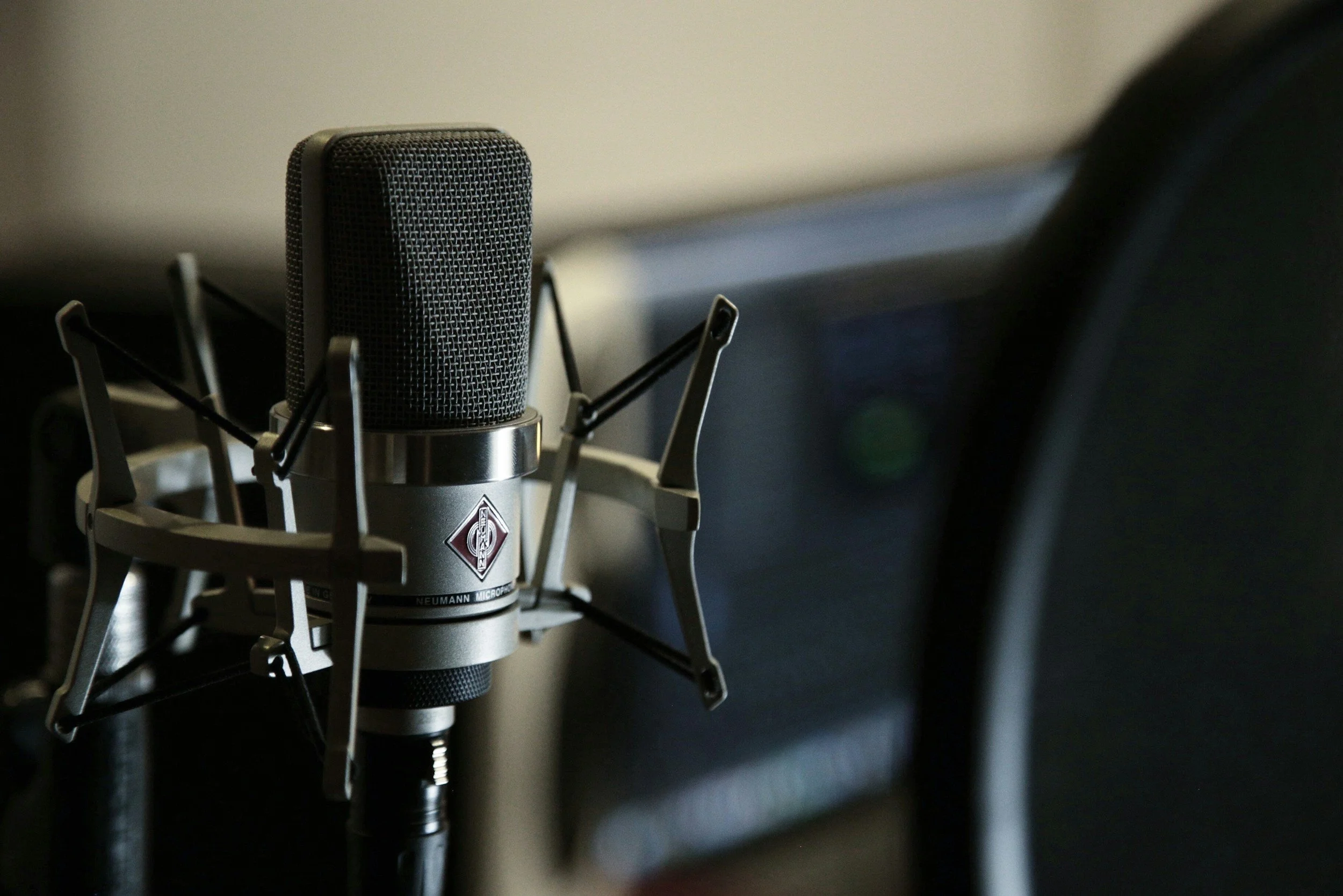 Close-up of a professional studio microphone, mounted on a shock mount.