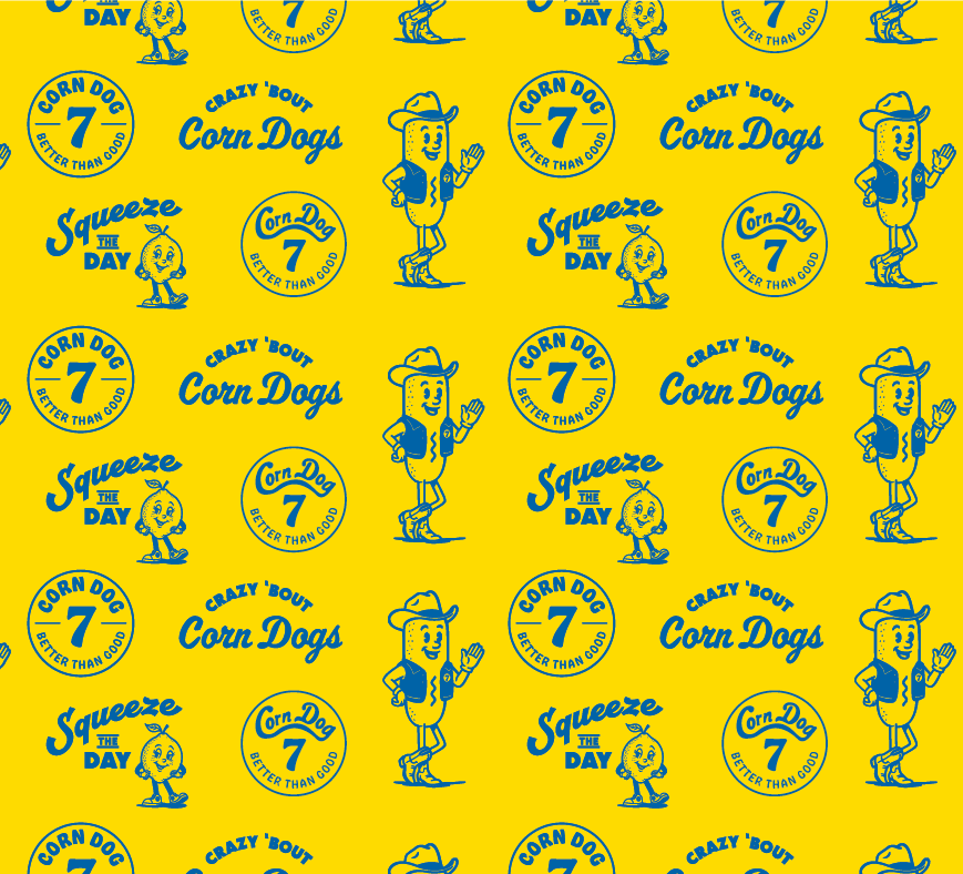 Pattern featuring cartoon hot dog character wearing a hat, with text including "Crazy 'Bout Corn Dogs," "Squeeze the Day," and "Corn Dog 7 Better Than Good" on a yellow background.