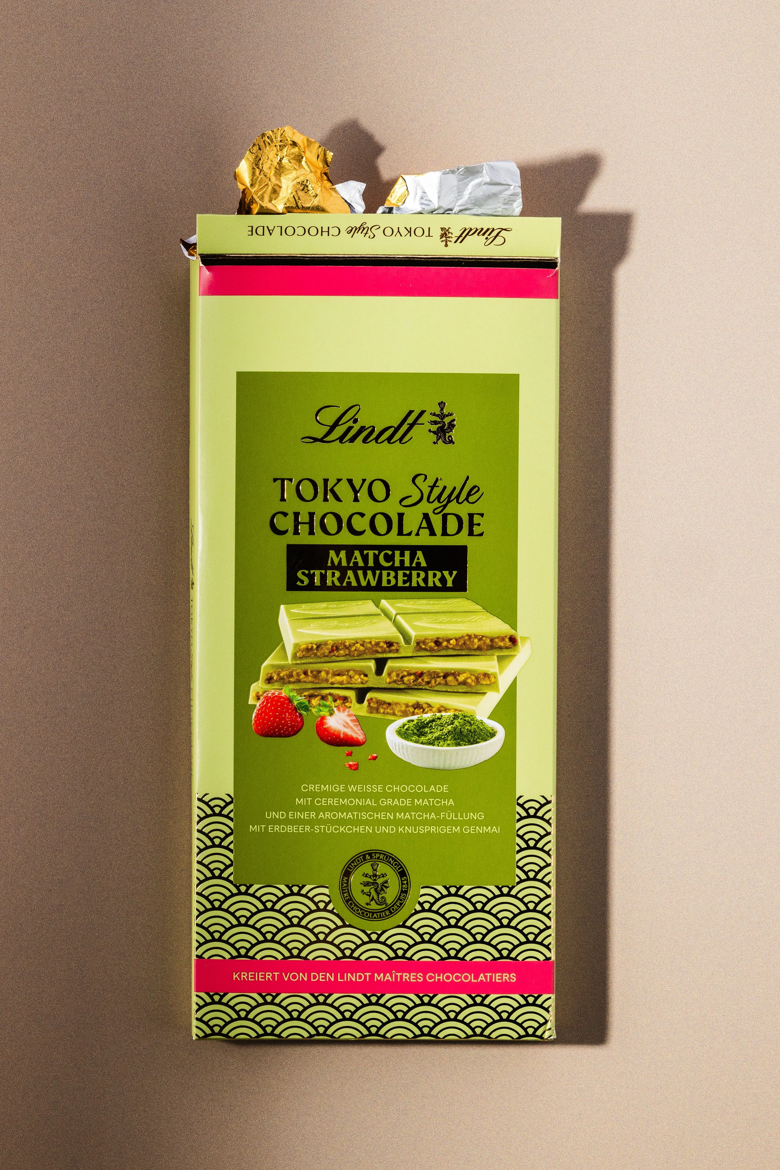 Grünes Lindt-Produktpaket mit Schokoladentafel, Erdbeeren und Matcha-Pulver, mit japanischem Design und goldenen Akzenten.