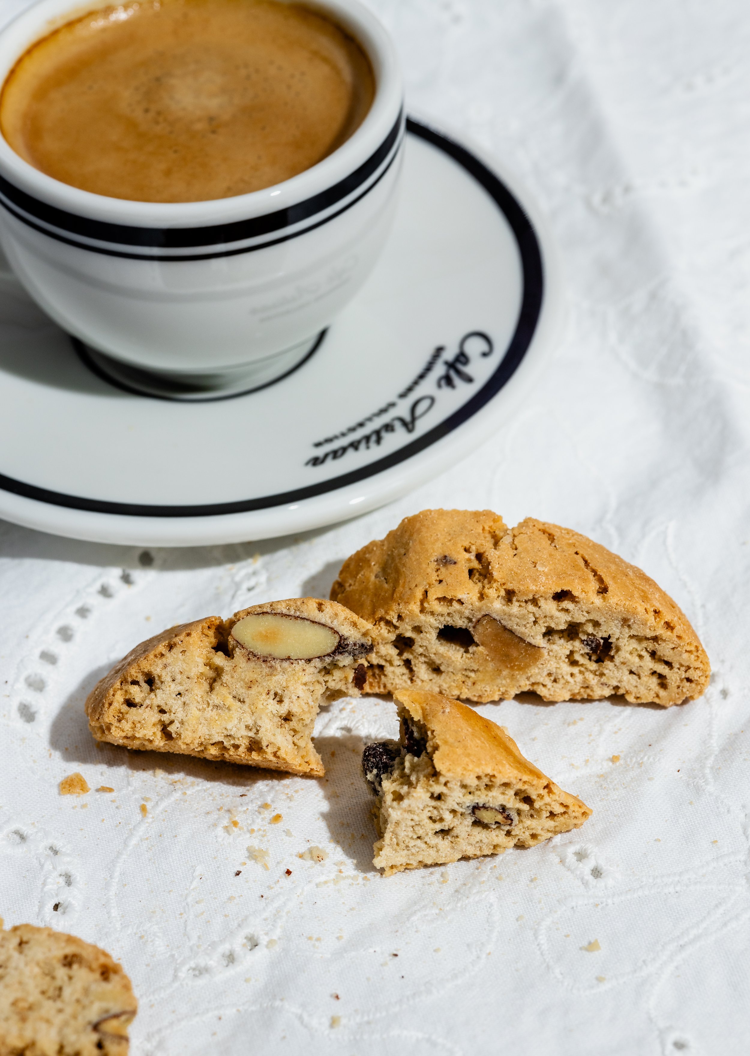 Ein Teller mit einem halben Cookies und einer Tasse Kaffee oder Espresso