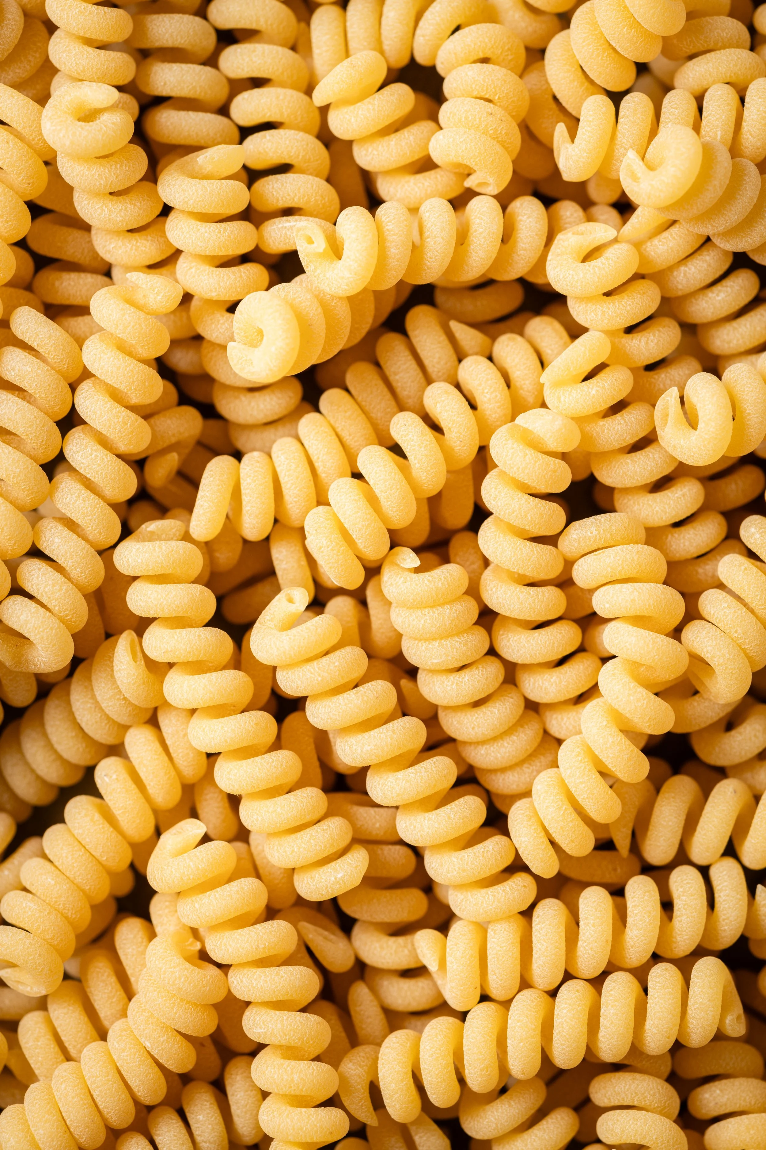 Verschiedene ungekochte Fusilli-Nudeln in Nahaufnahme