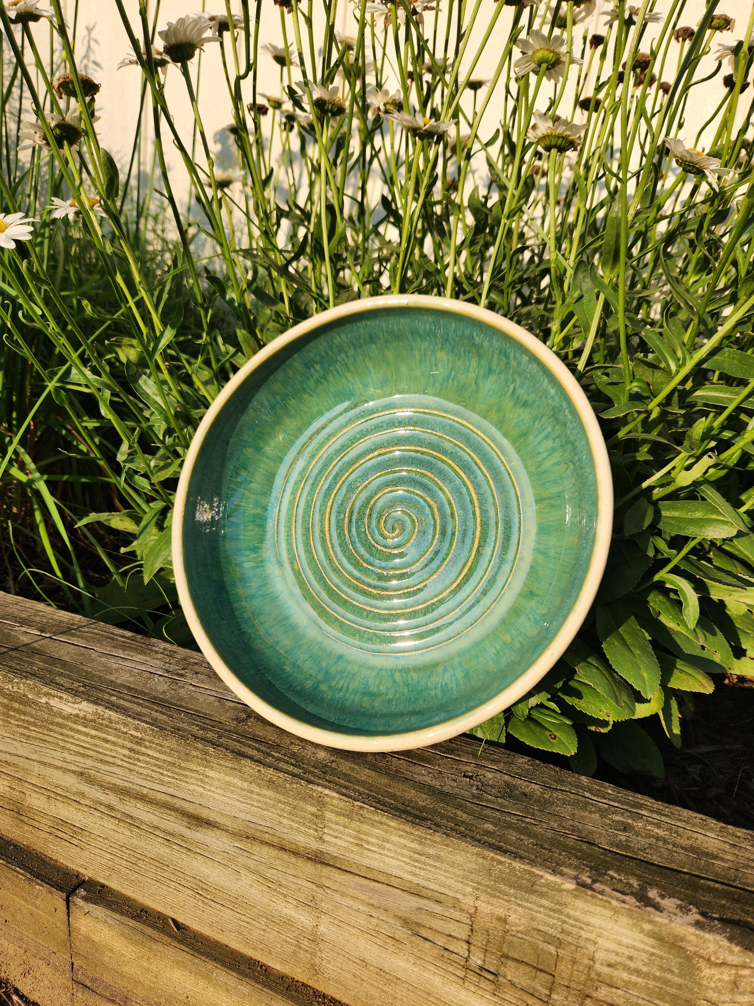 Shallow bowl with green interior glaze and swirled bottom and birch-bark exterior glaze.