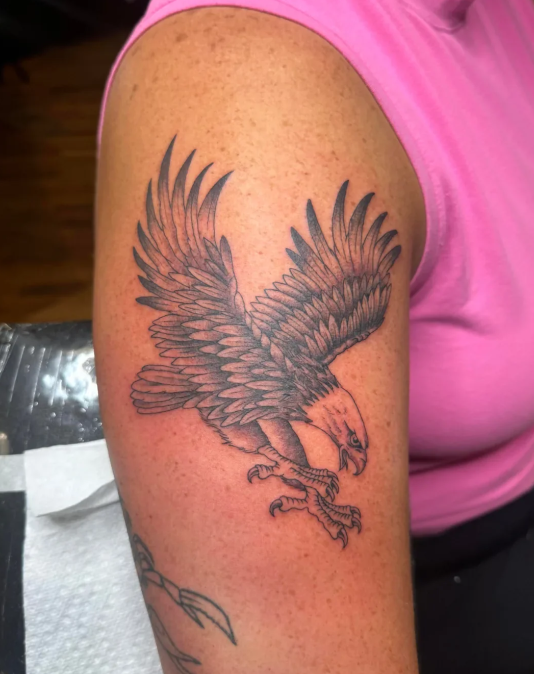 Majestic bald eagle tattoo with wings fully spread in flight, detailed feather work and dotwork shading. Powerful Americana piece by Brett Semrick.	e