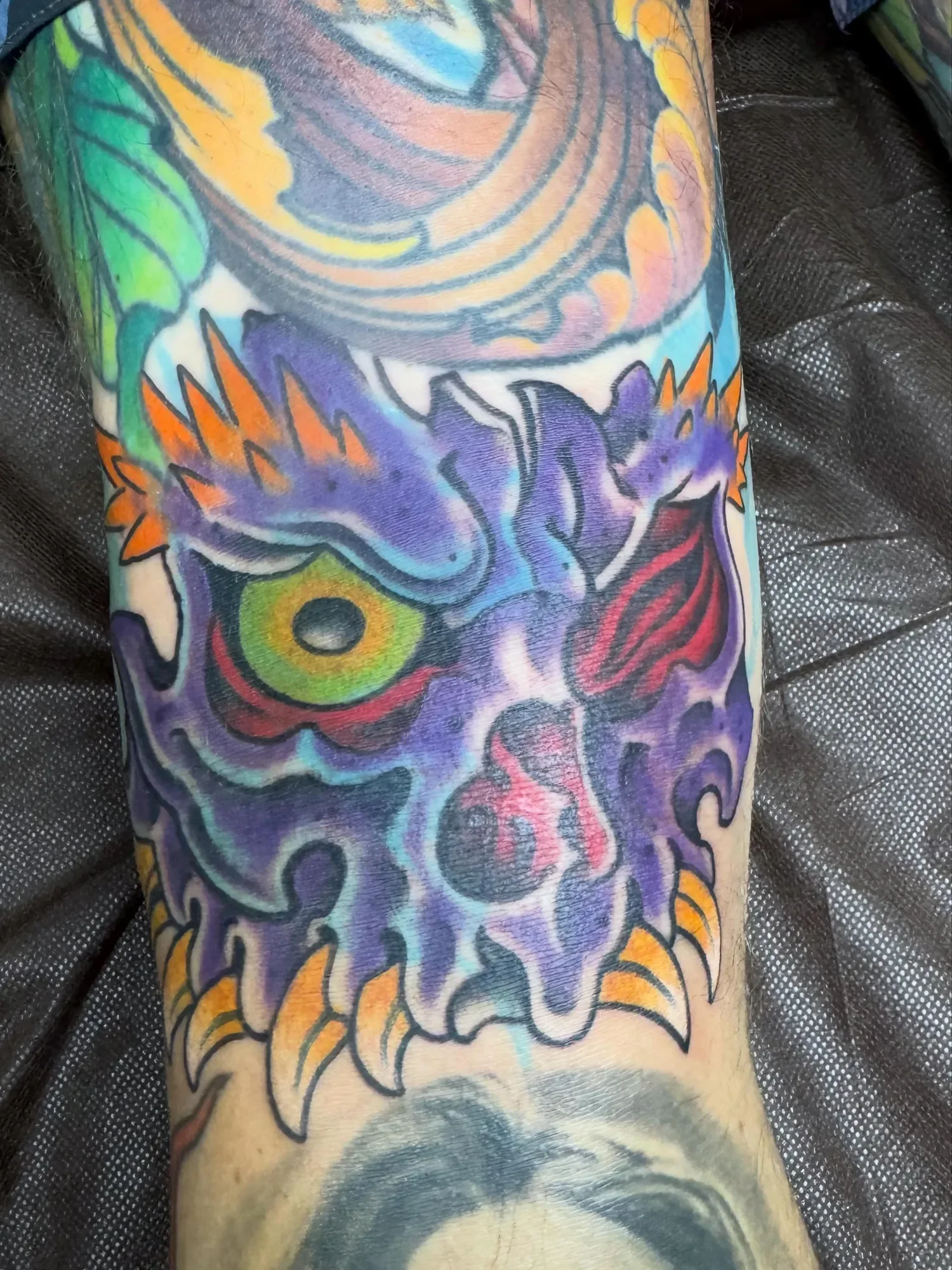 Colorful tattoo of a tiger's face on a person's arm.