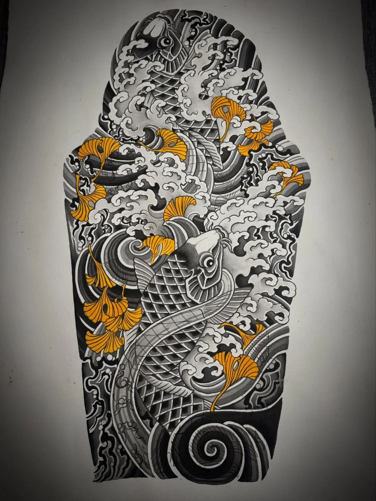 Black and white tattoo-style illustration featuring a koi fish, swirling waves, clouds, and orange ginkgo leaves.