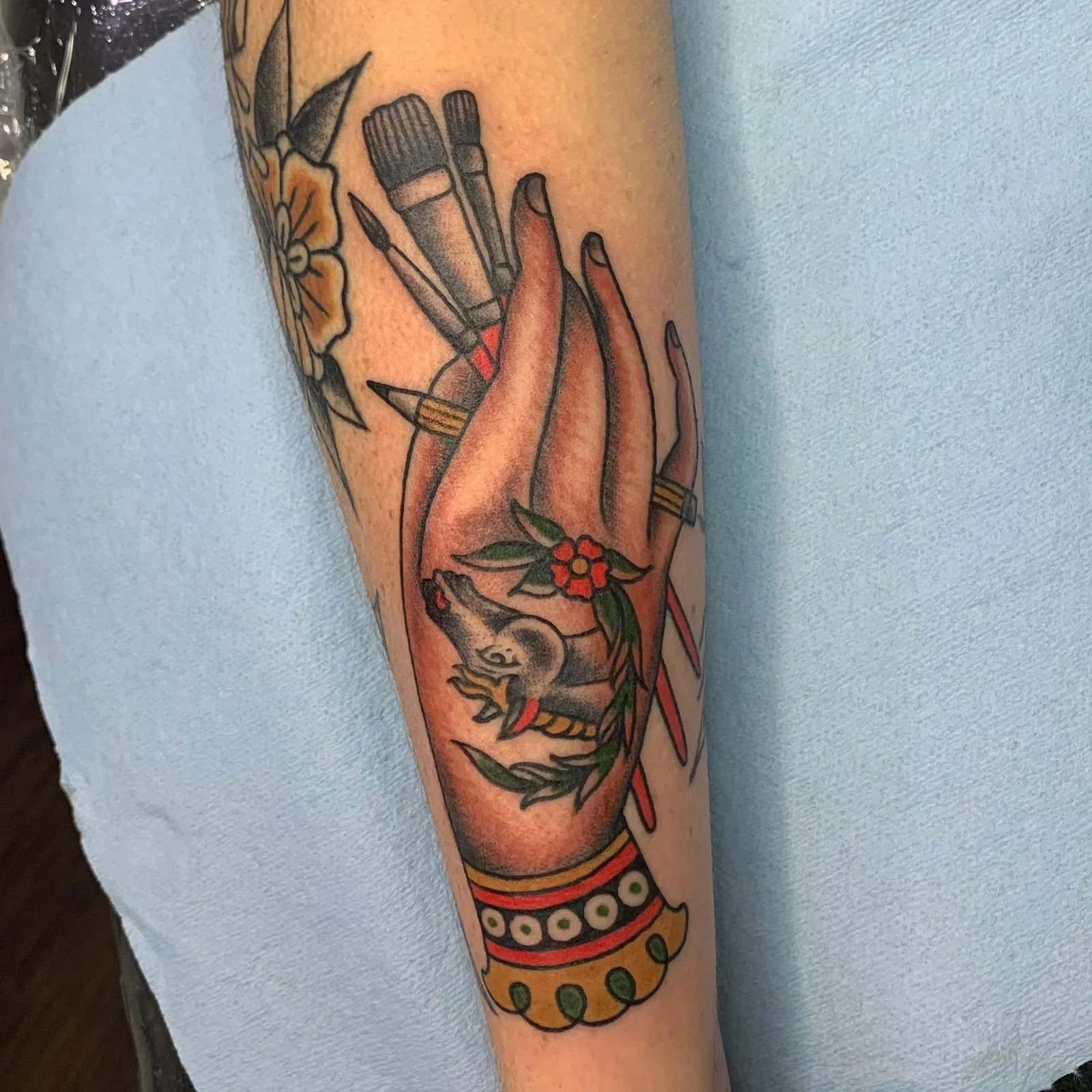 Painter's hand — ornamental cuff, brushes, pencil, red flower and horse head detail. For creatives, by a creative.
