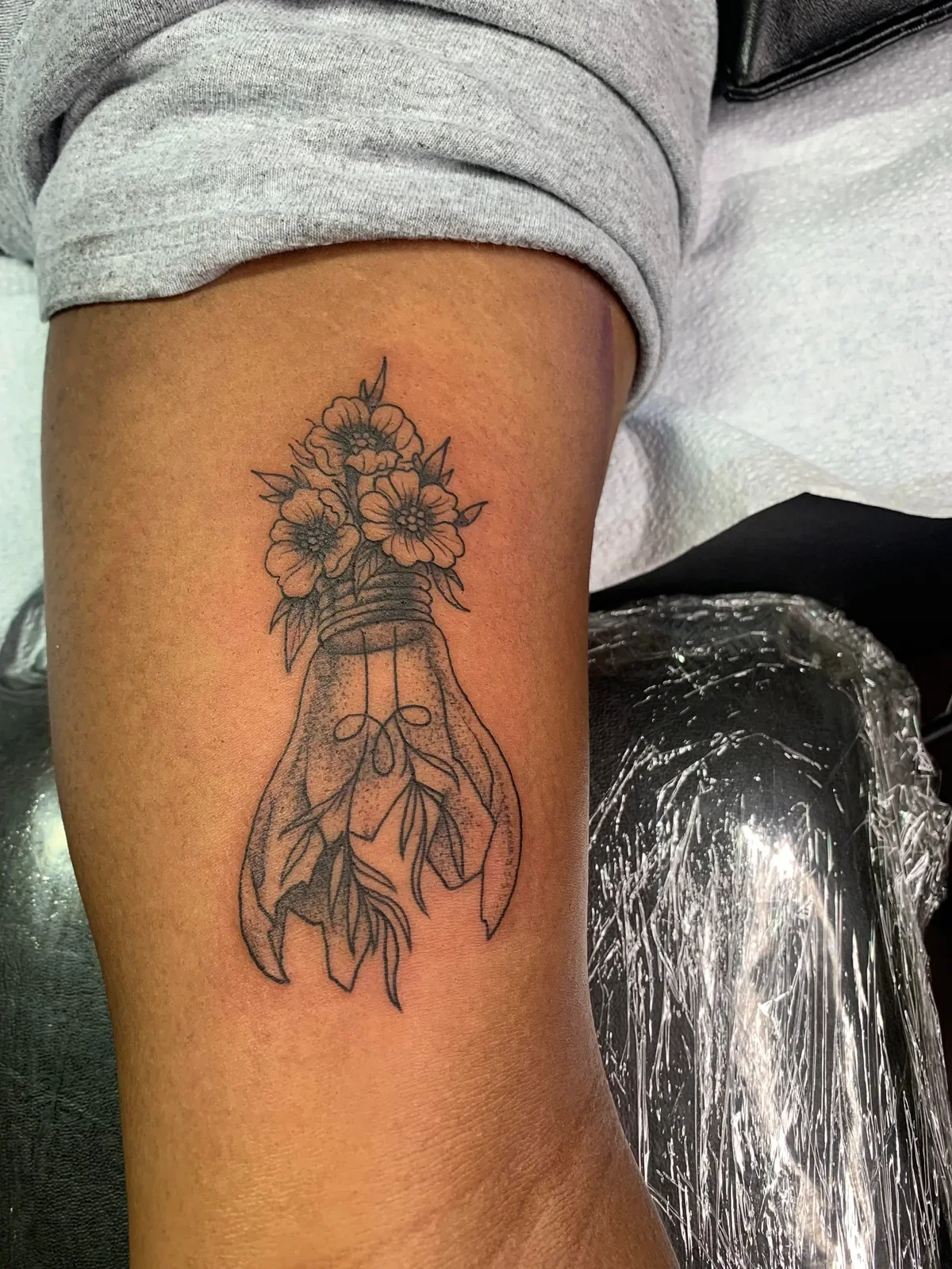 Creative botanical tattoo of wildflowers blooming from a broken lightbulb with leaves inside. Fine line blackwork with dotwork shading by Brett Semrick.