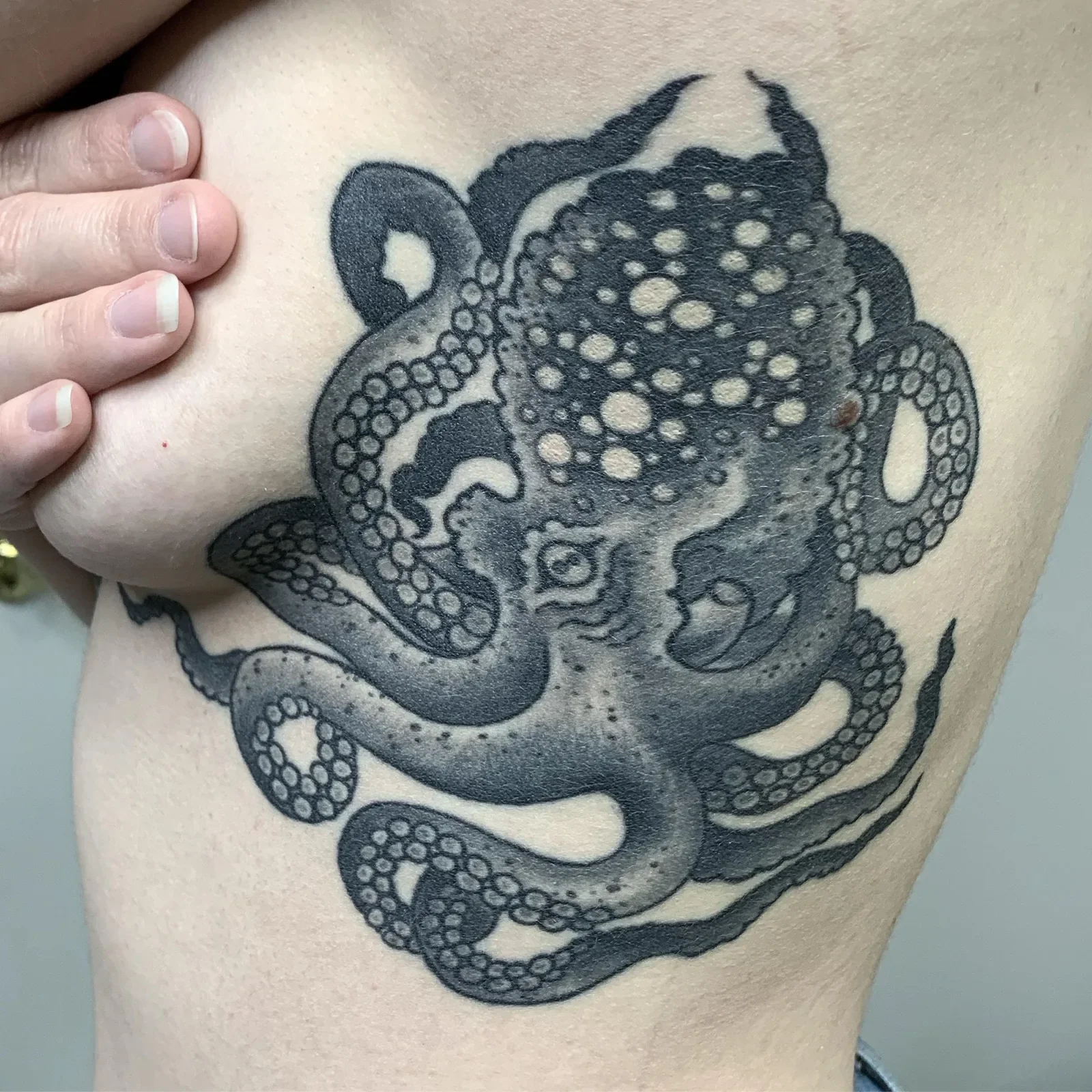 Large-scale healed octopus with dotwork shading and stippled suckers — bold blackwork built for side/rib placement.
