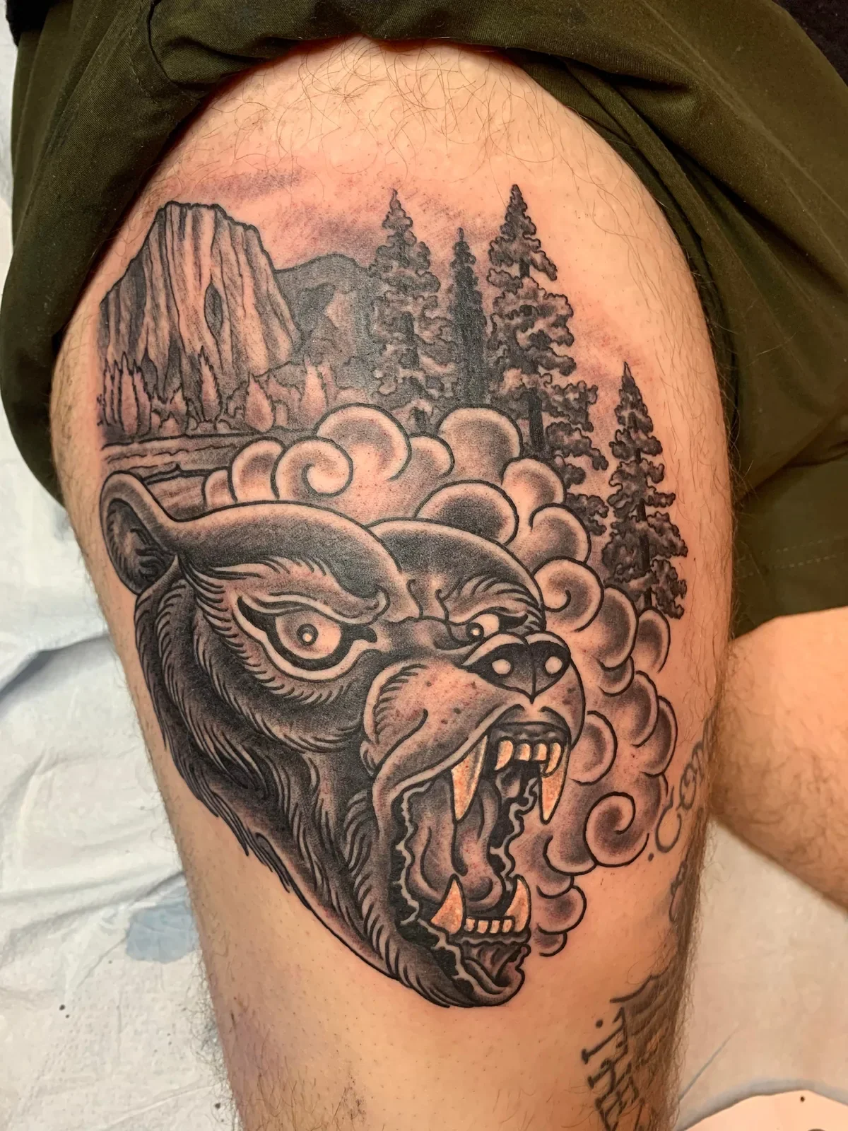 Roaring bear emerging from clouds with Yosemite Valley backdrop — California blackwork trad.
