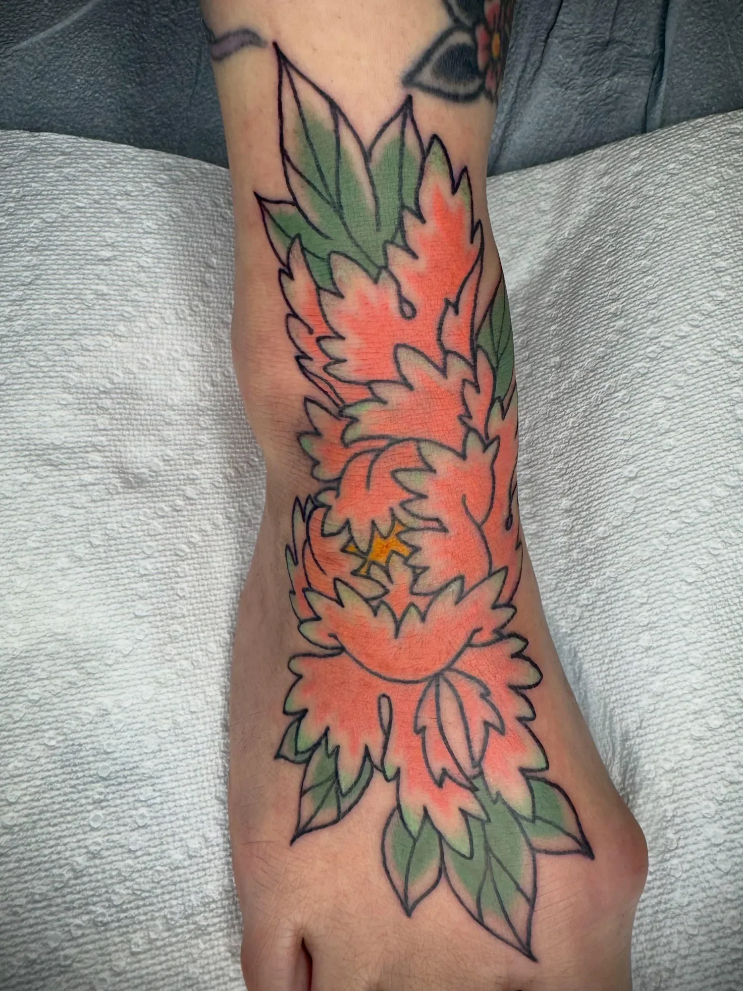Peony foot top in progress — soft pink to green fade, bold outline to hold on a tough spot. Classic Japanese floral.
