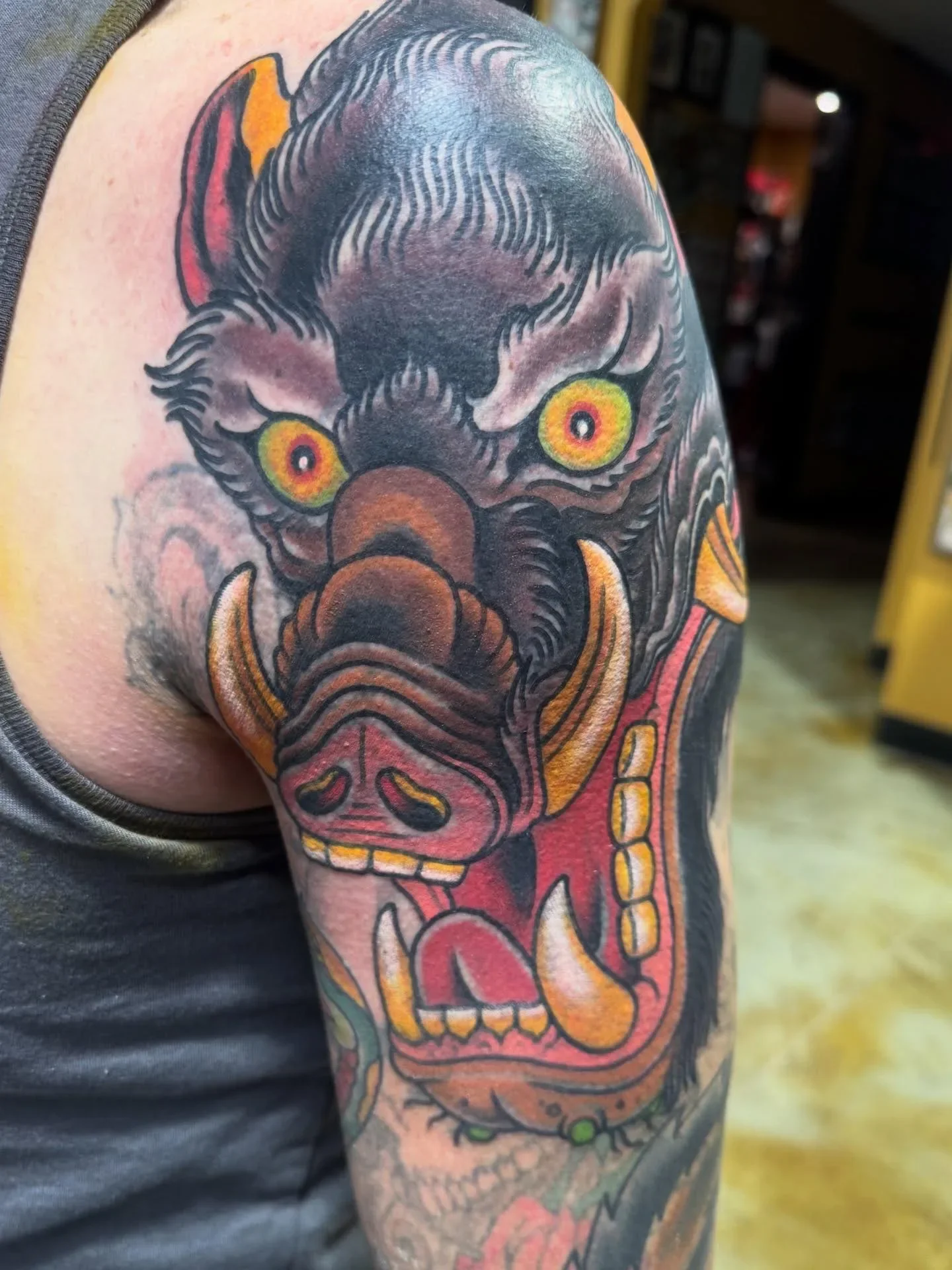 Bold color traditional Japanese wild boar yokai tattoo - large Inoshishi demon with yellow eyes, tusks and open mouth. Heavy traditional Japanese influenced work by Brett Semrick.
